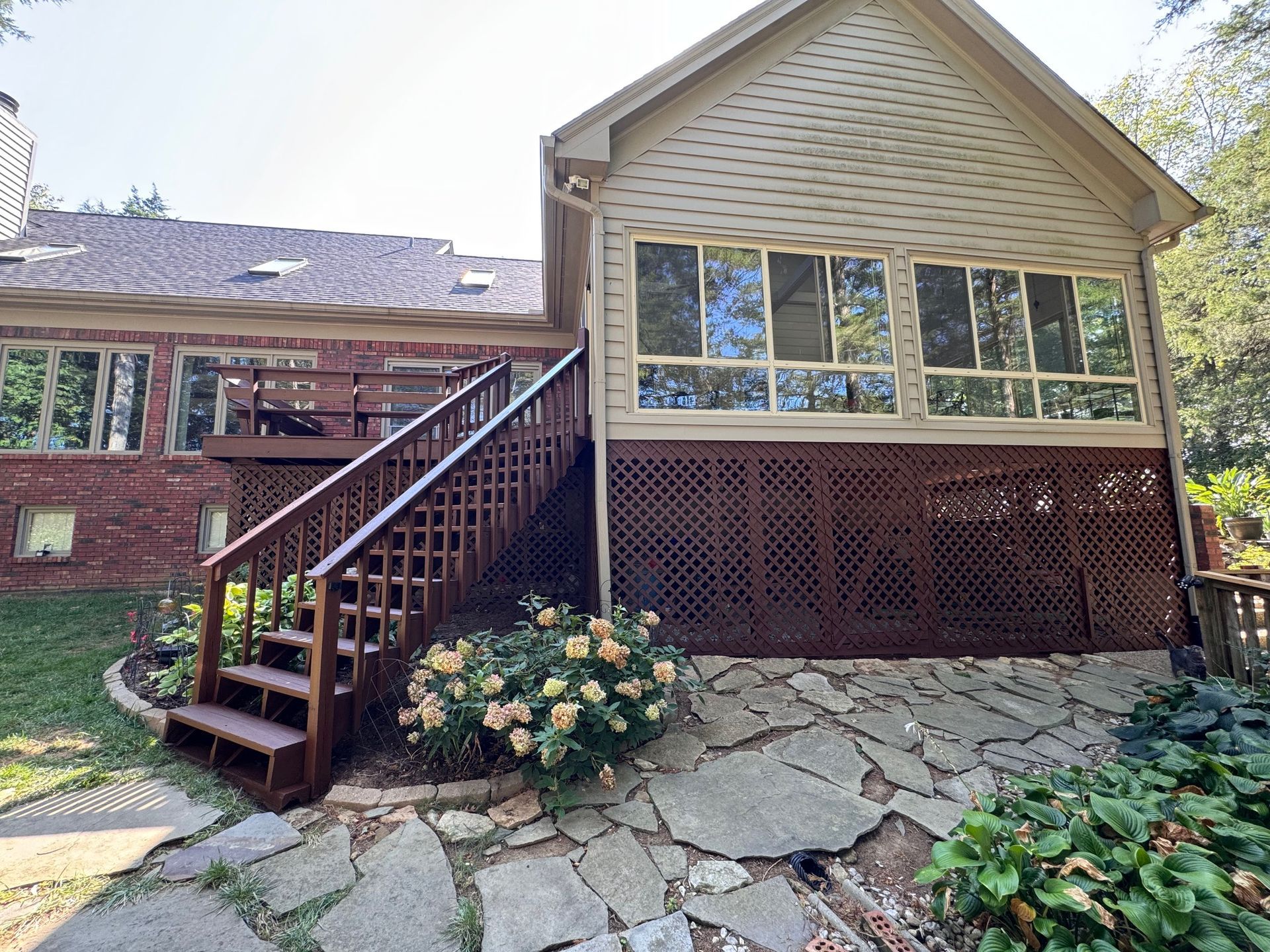 A house with a large deck and stairs leading up to it.
