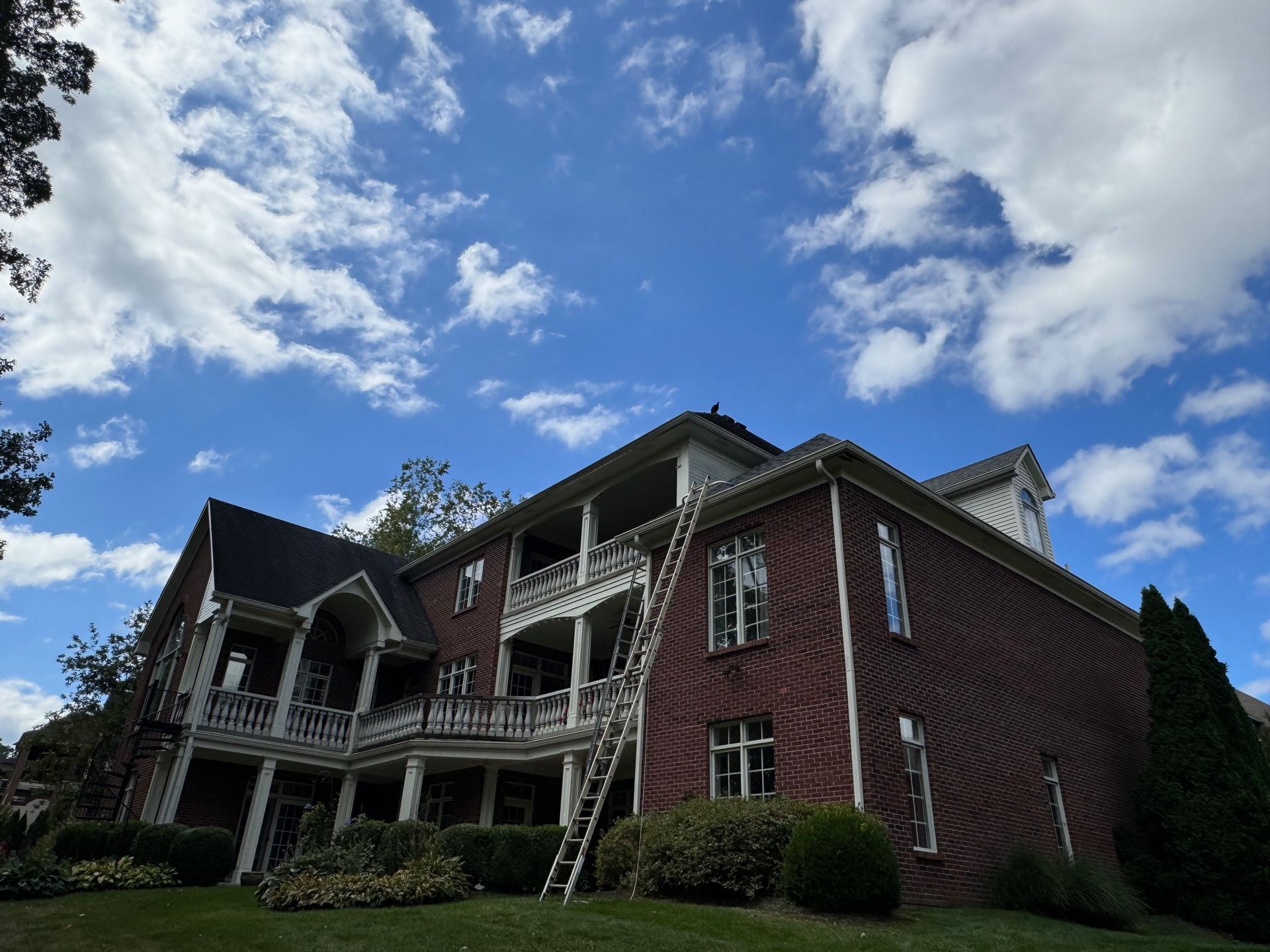 A large brick house with a ladder on the side of it