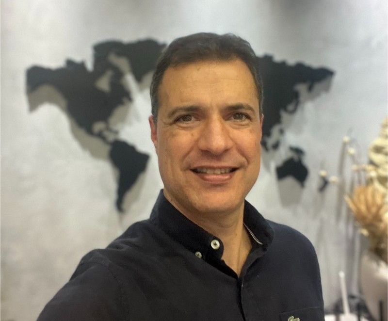 Um homem está tirando uma selfie em frente a um mapa do mundo.