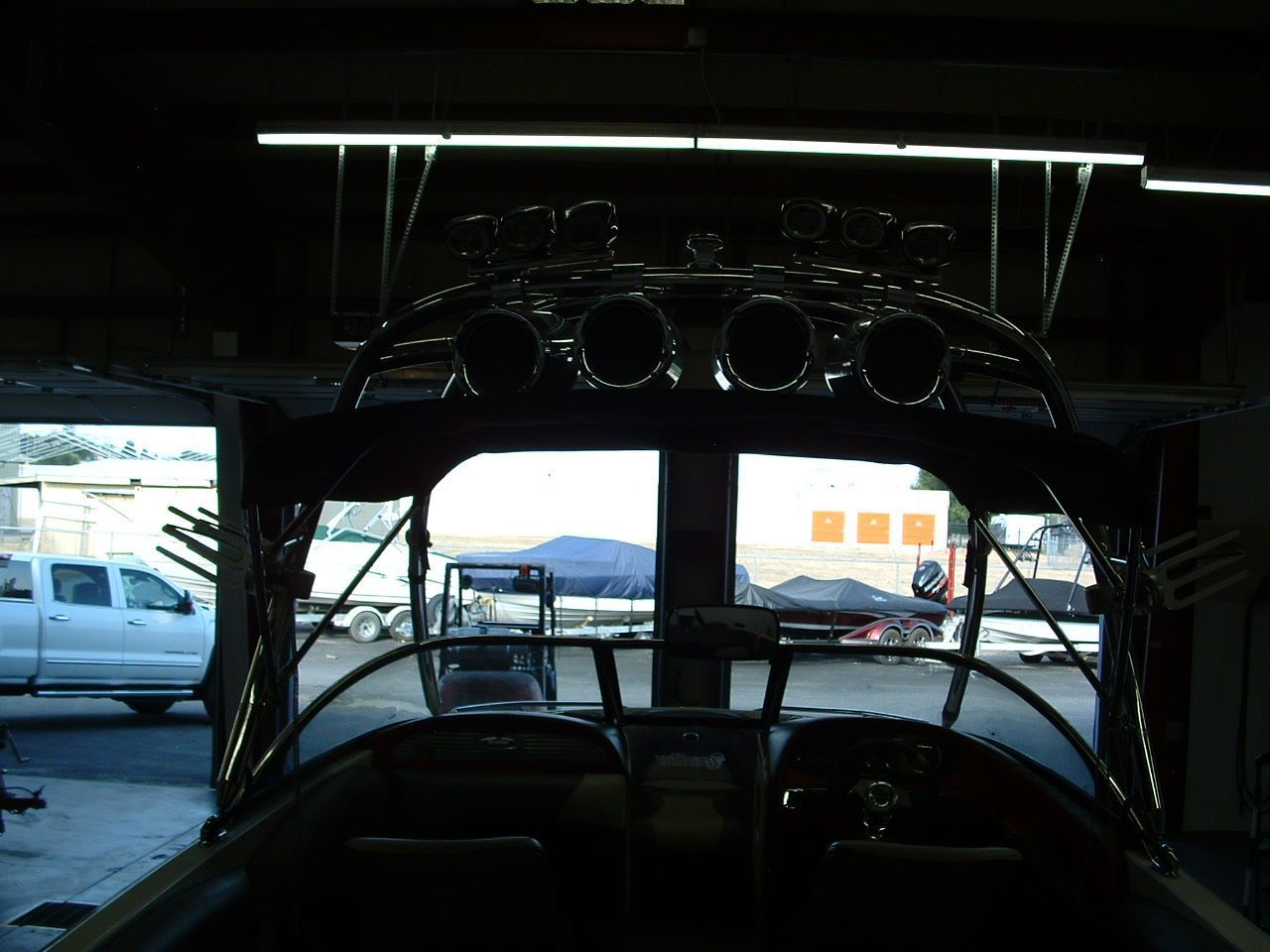 A boat in a garage with speakers on top of it