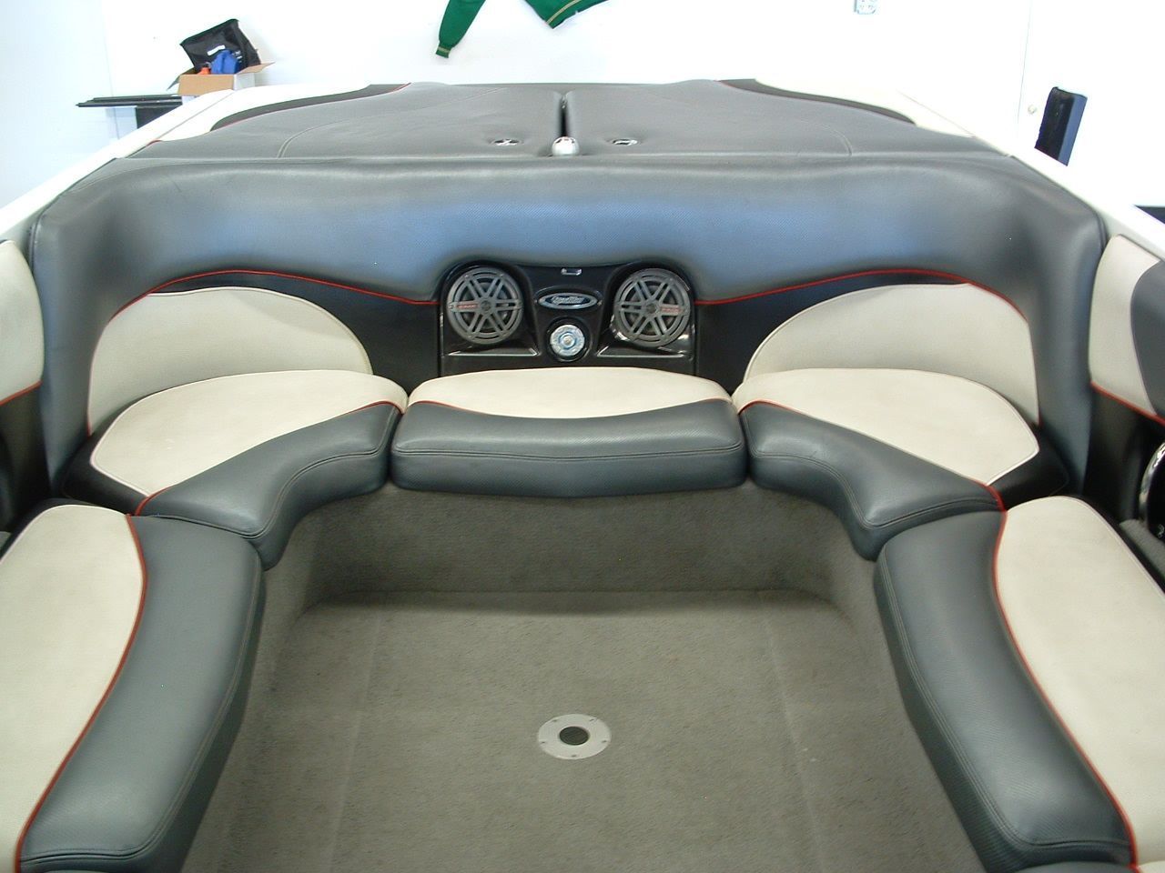 A boat with black and white seats and speakers on the back