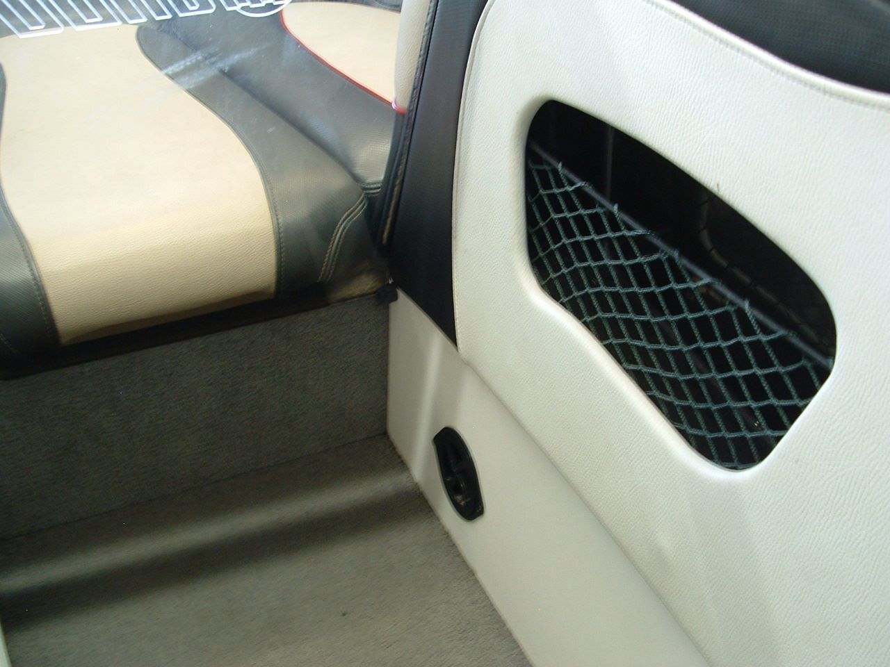 A close up of a boat seat with a mesh pocket
