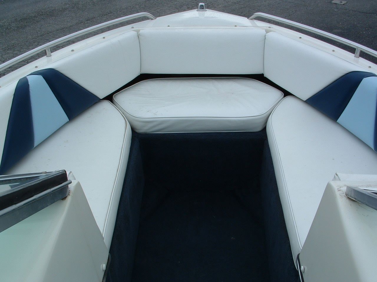 The inside of a boat with white and blue seats