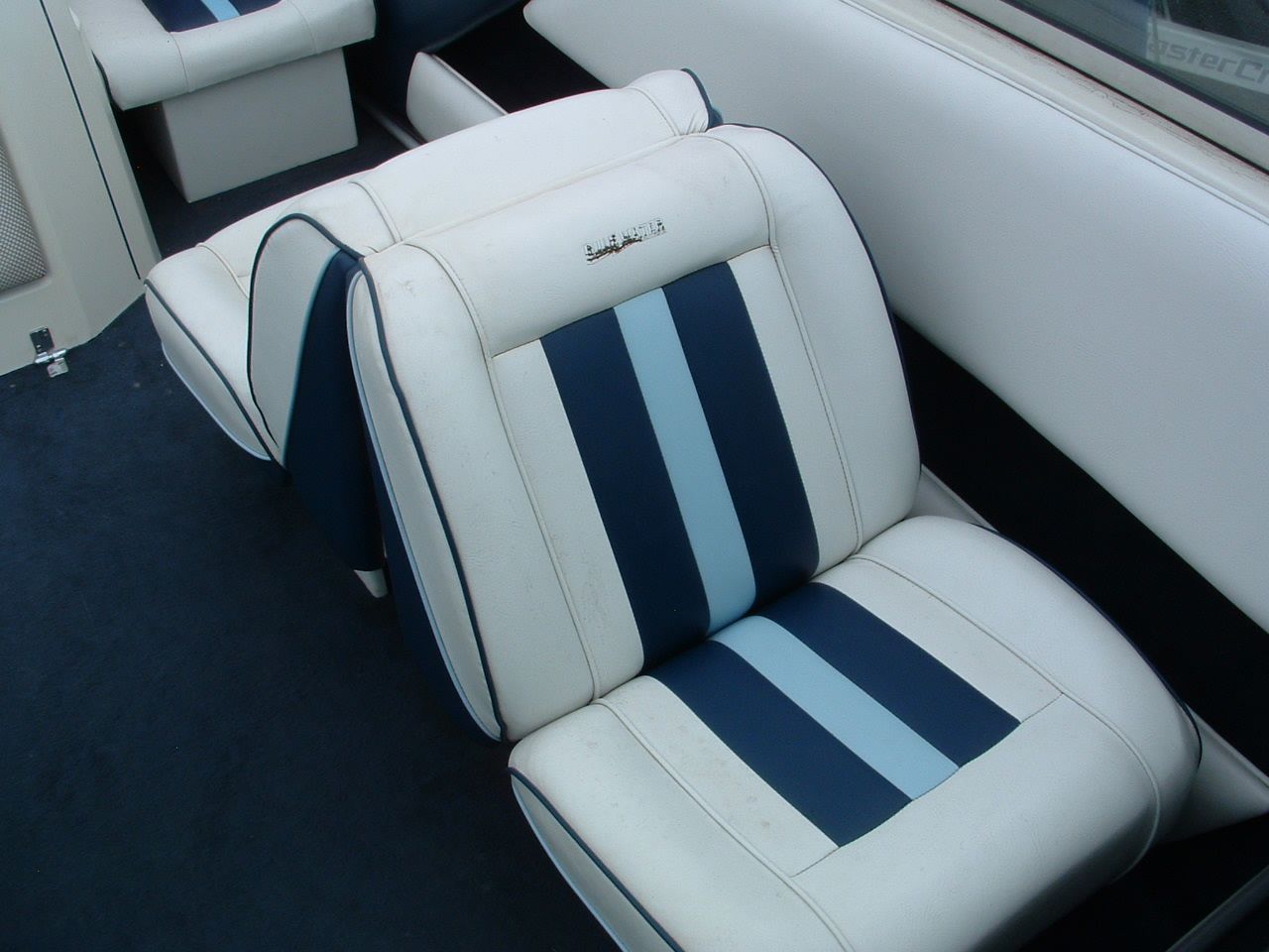 A blue and white striped seat on a boat