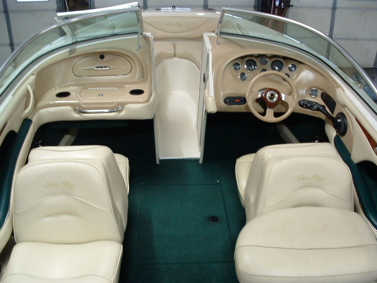 The inside of a boat with a steering wheel and seats