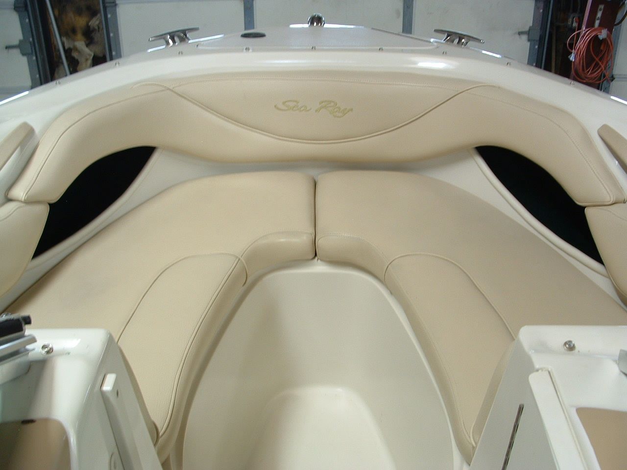 A white boat with tan seats and the word sea ray on the front