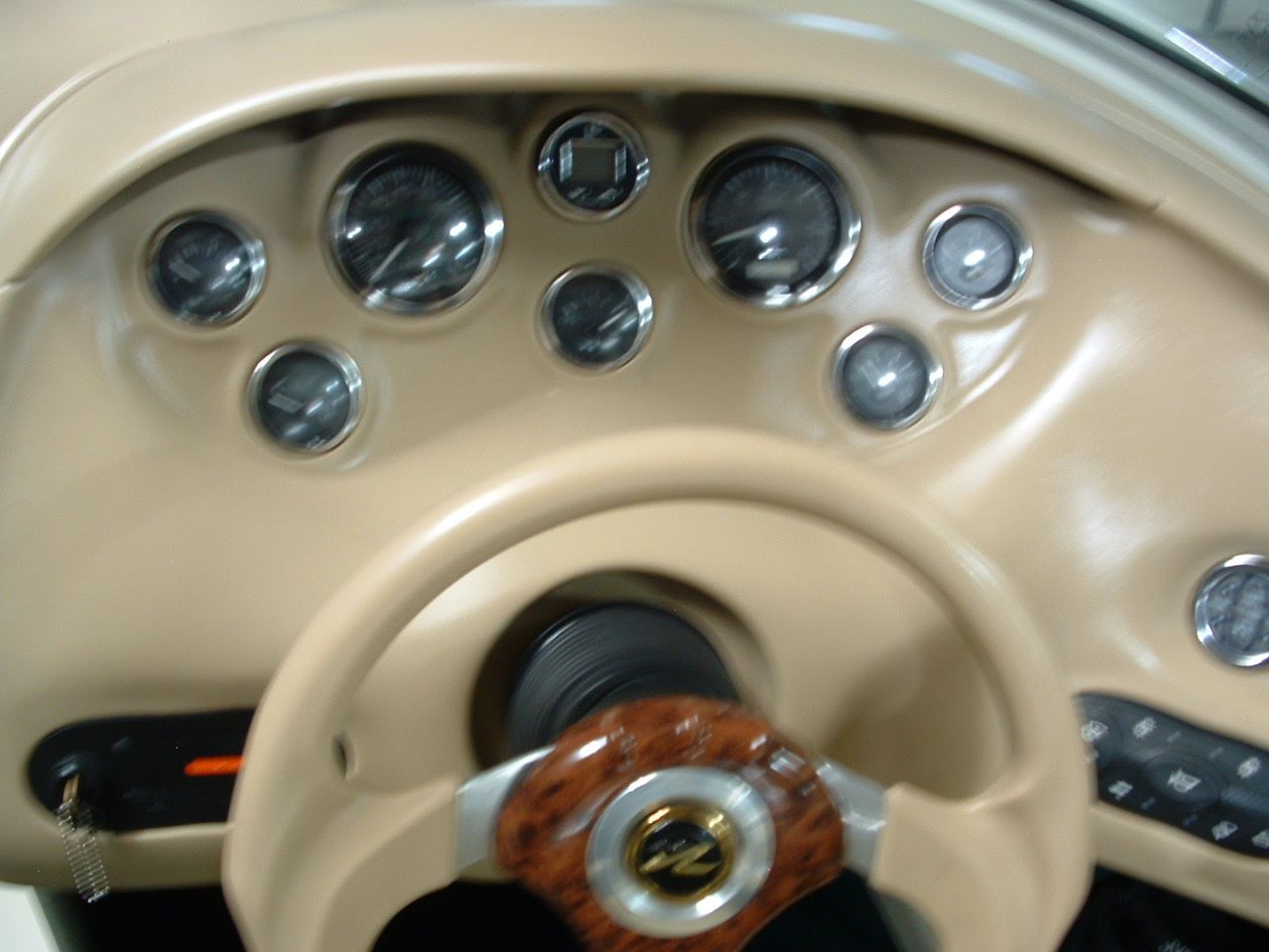 A close up of a steering wheel and dashboard of a boat