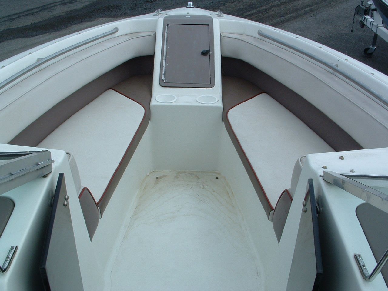 The front of a white boat with brown seats