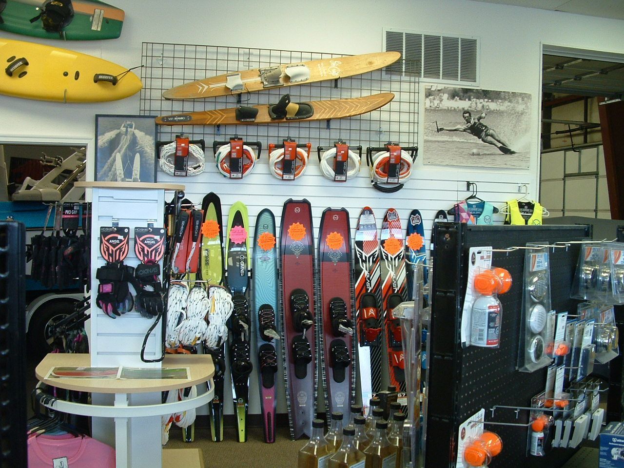 A bunch of skis are hanging on a wall in a store