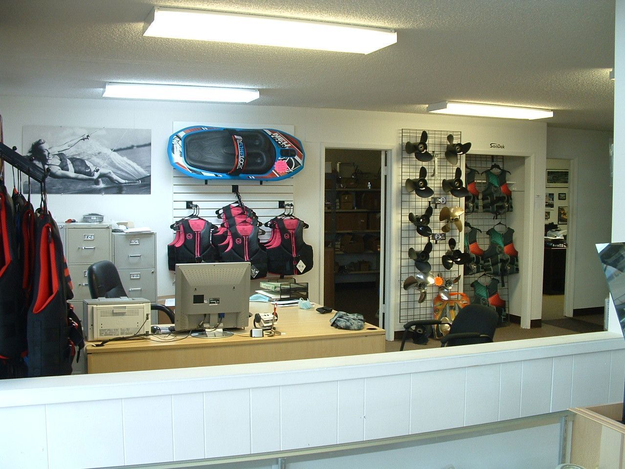 A room with a desk and a snowboard on the wall