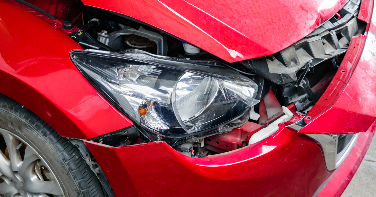 Red car engine bay with black engine cover and dipstick. | Stu's Collision Center