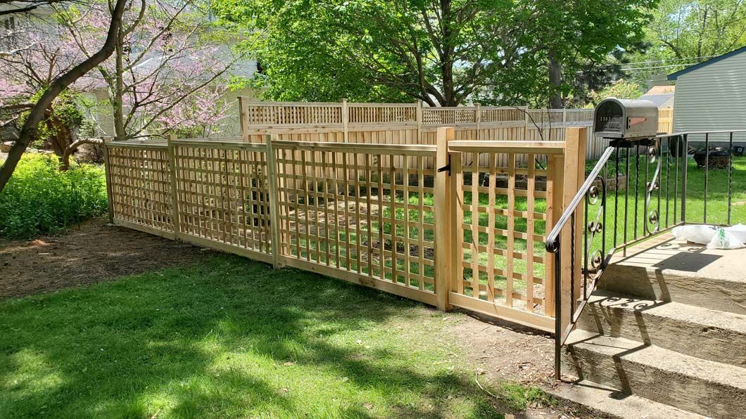 A wooden fence with a gate in the backyard of a house.
