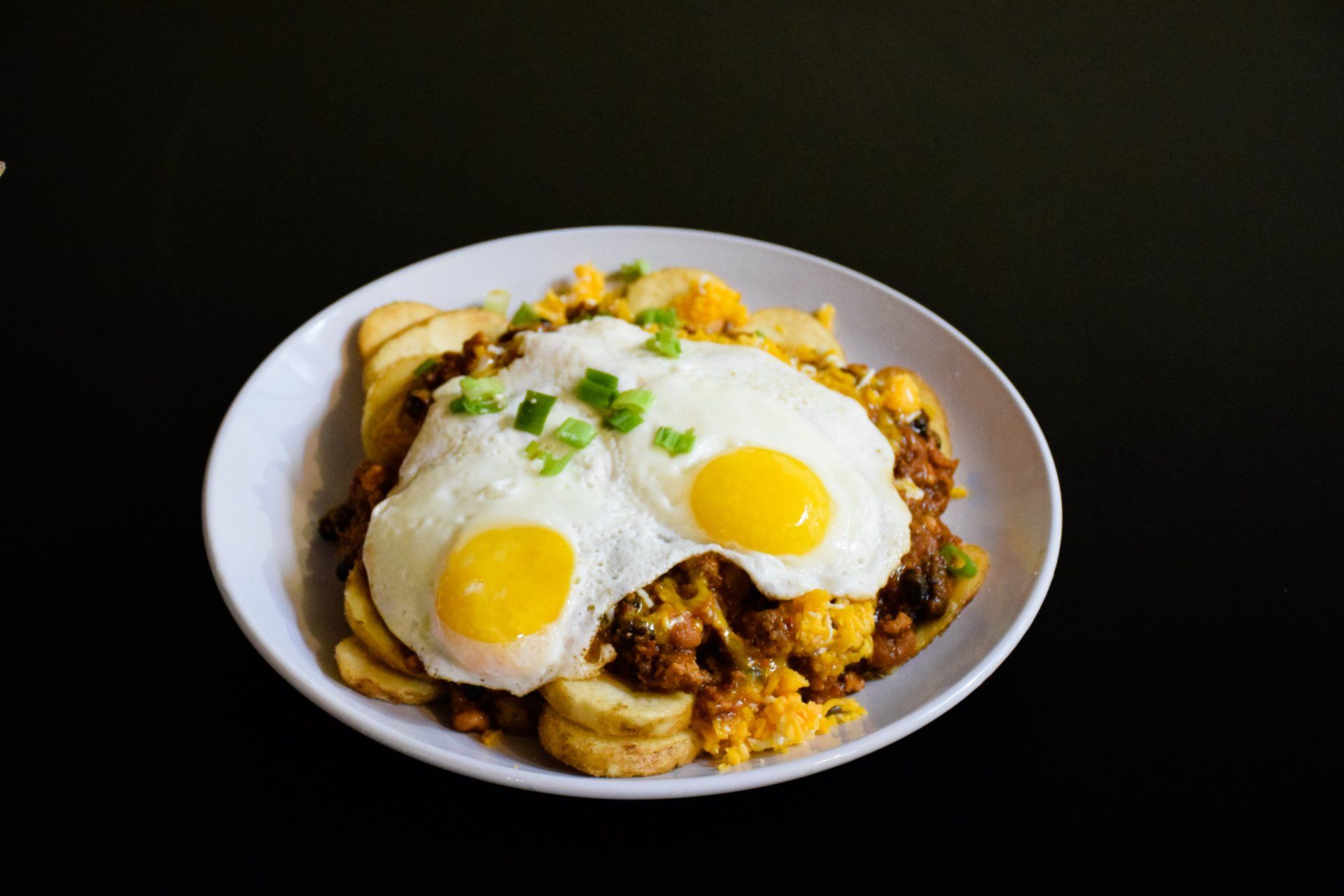 A plate of food with eggs and potatoes on a table.