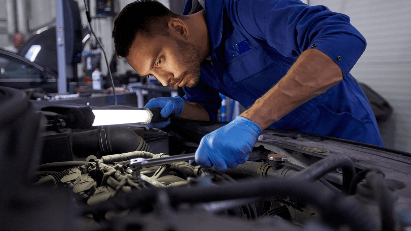 a mechanic looking under the hood of a car