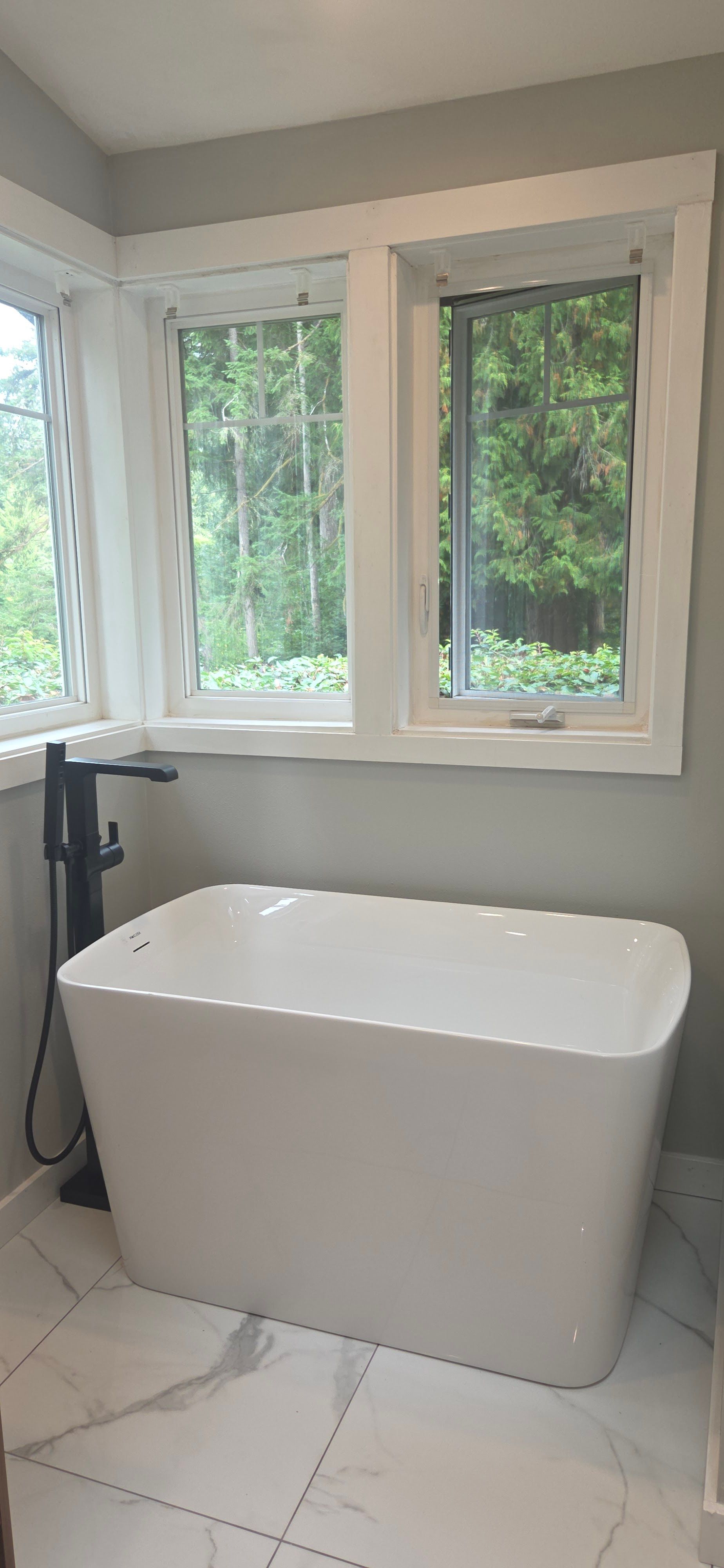 Bathroom vanity with wooden cabinets, white countertop, and silver faucet.