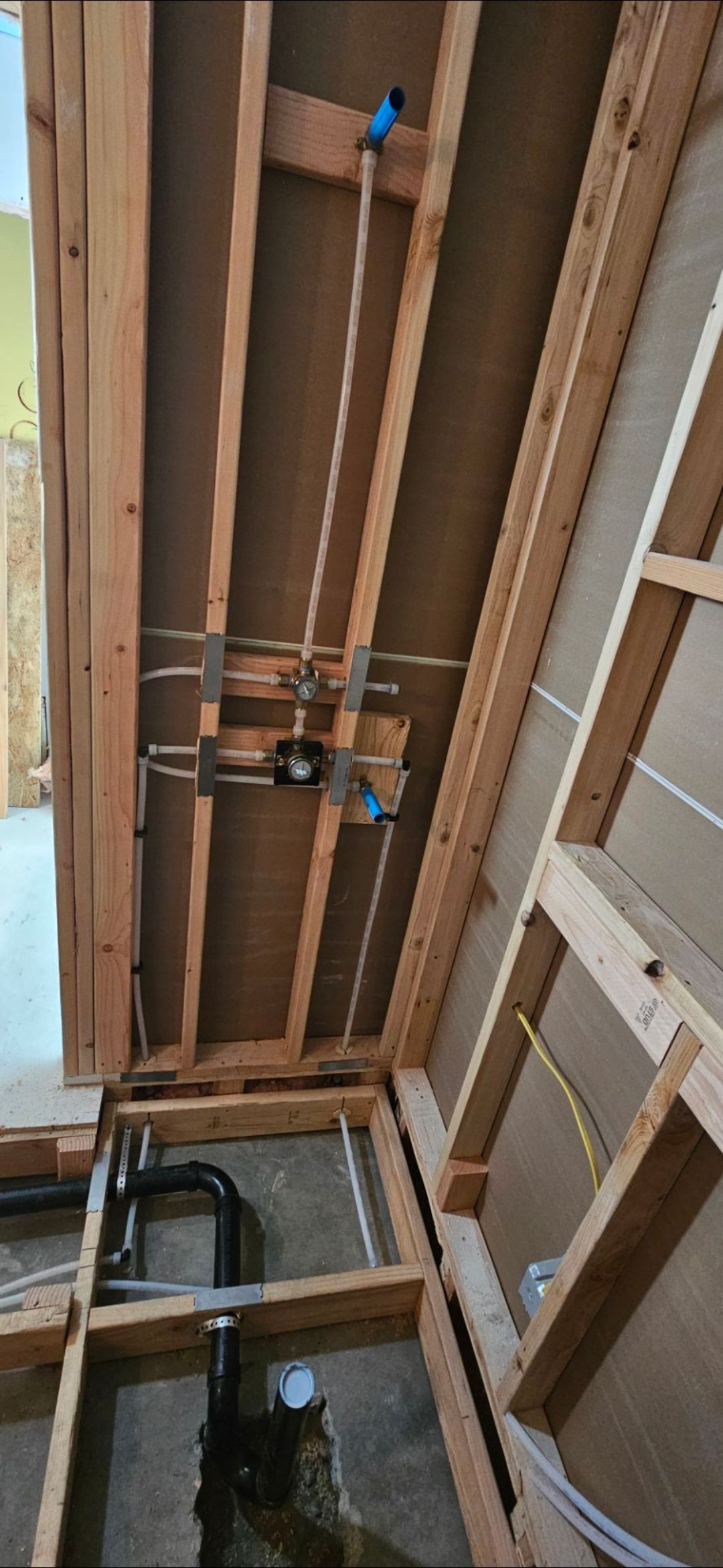 Construction framing showing plumbing and electrical work.