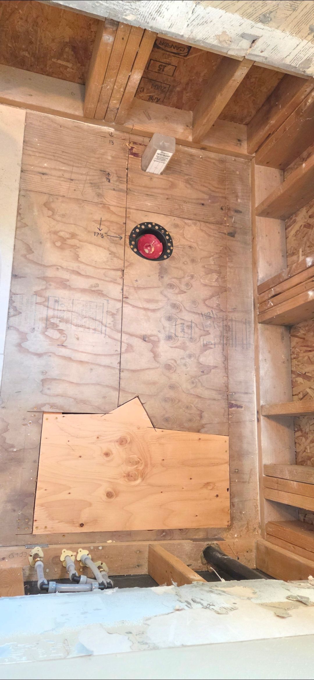 Interior view of a wooden framed structure with a red circular object embedded in the wall.