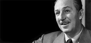 A man in a suit and tie is smiling in a black and white photo.