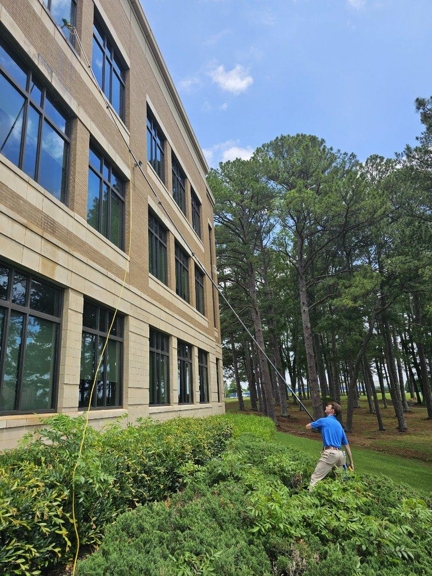 A man is cleaning the windows of a wooden house