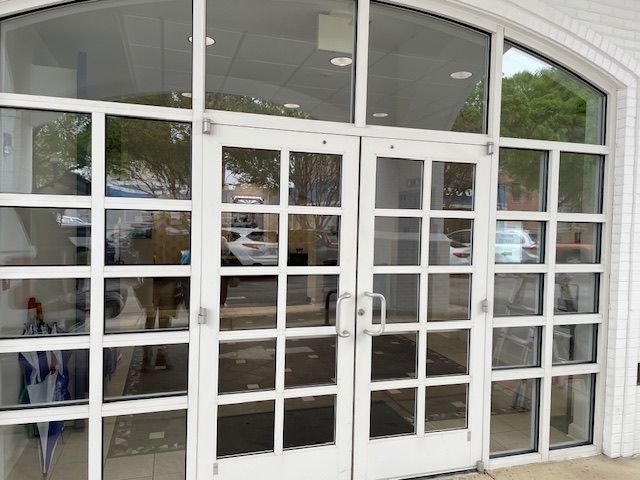 A man is cleaning a large window with a sponge.