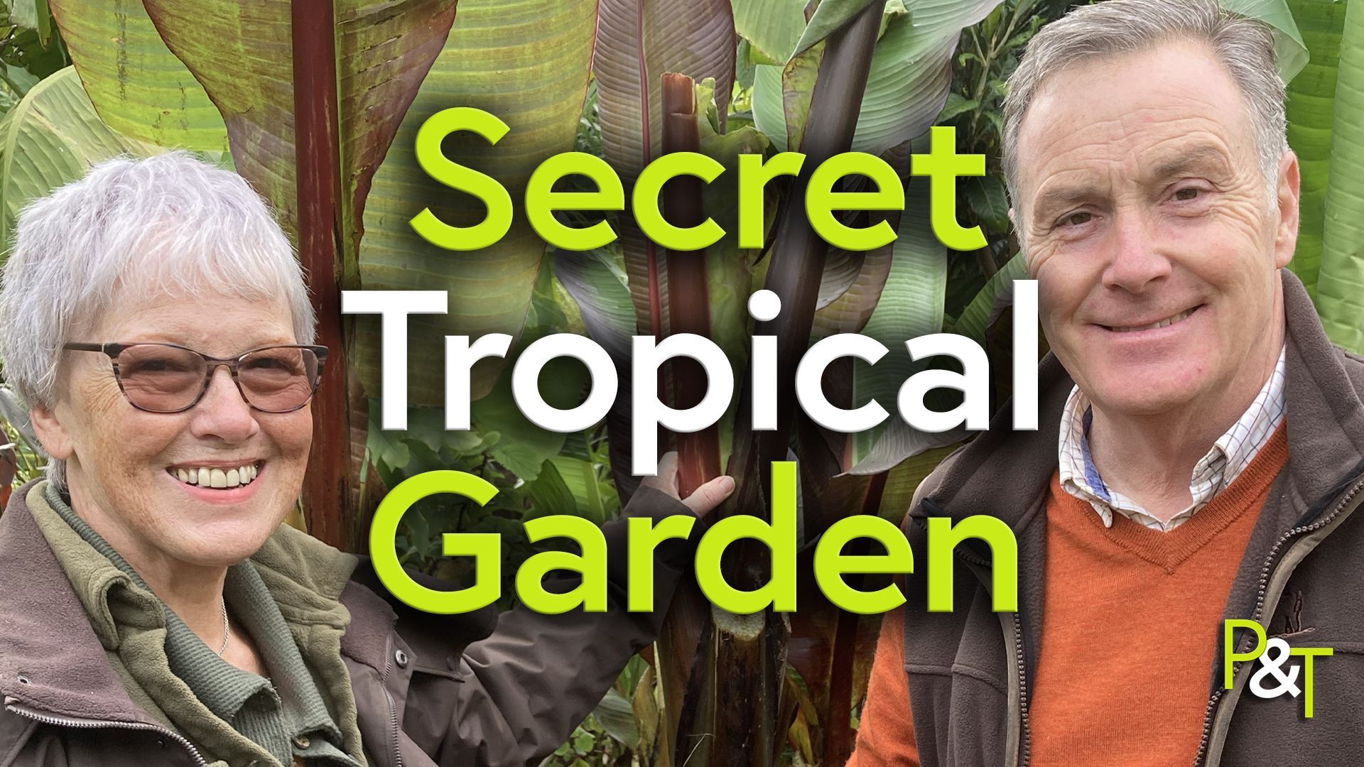 Jenny Grasham and Martin Fish stand next to each other facing the camera. They are both wearing autumnal clothes in browns and greens and between them is a huge banana plant. over the top of the plant in between them is the text Secret Tropical Garden in green and white lettering. The PT logo is in the corner of the image, again in green and white.