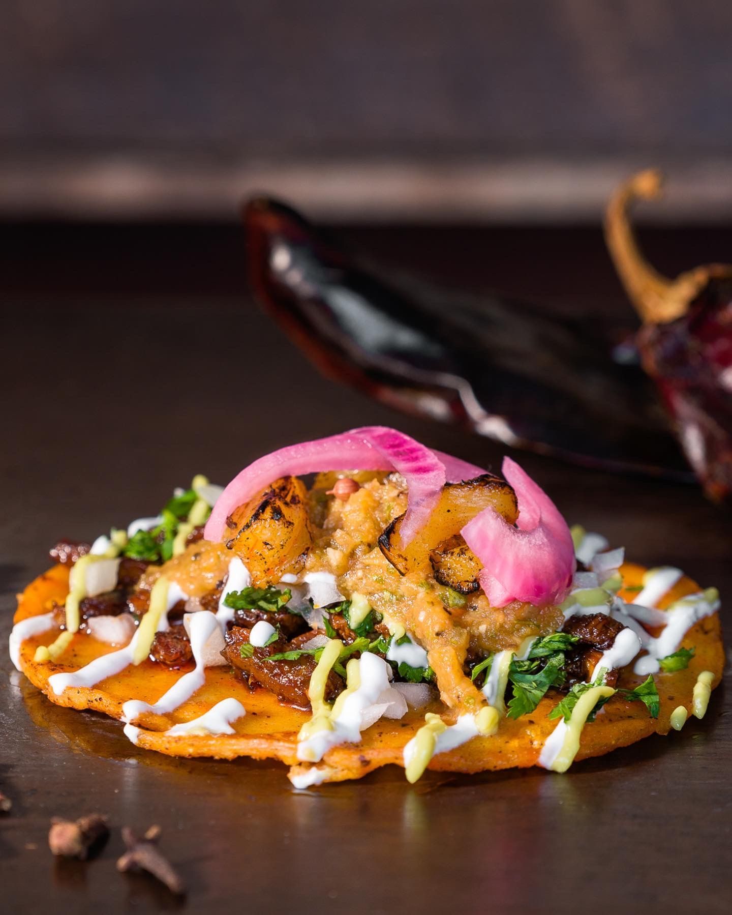Sonoran street taco handheld close-up showing fresh toppings and salsa