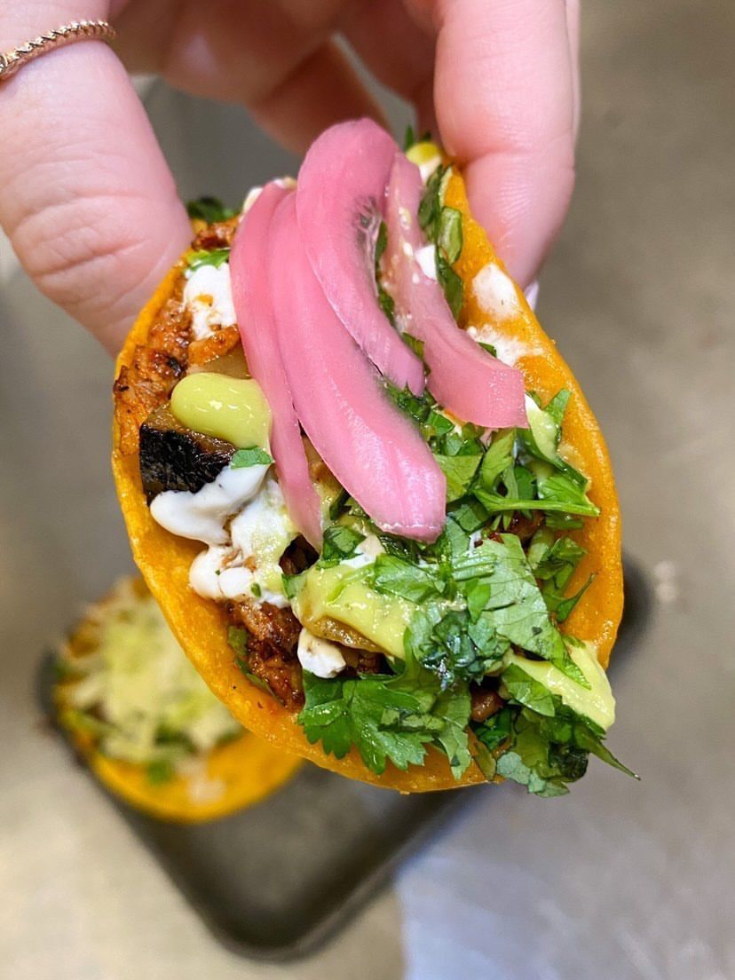 Adobada taco with grilled pineapple, cilantro, red onions and salsa closeup.