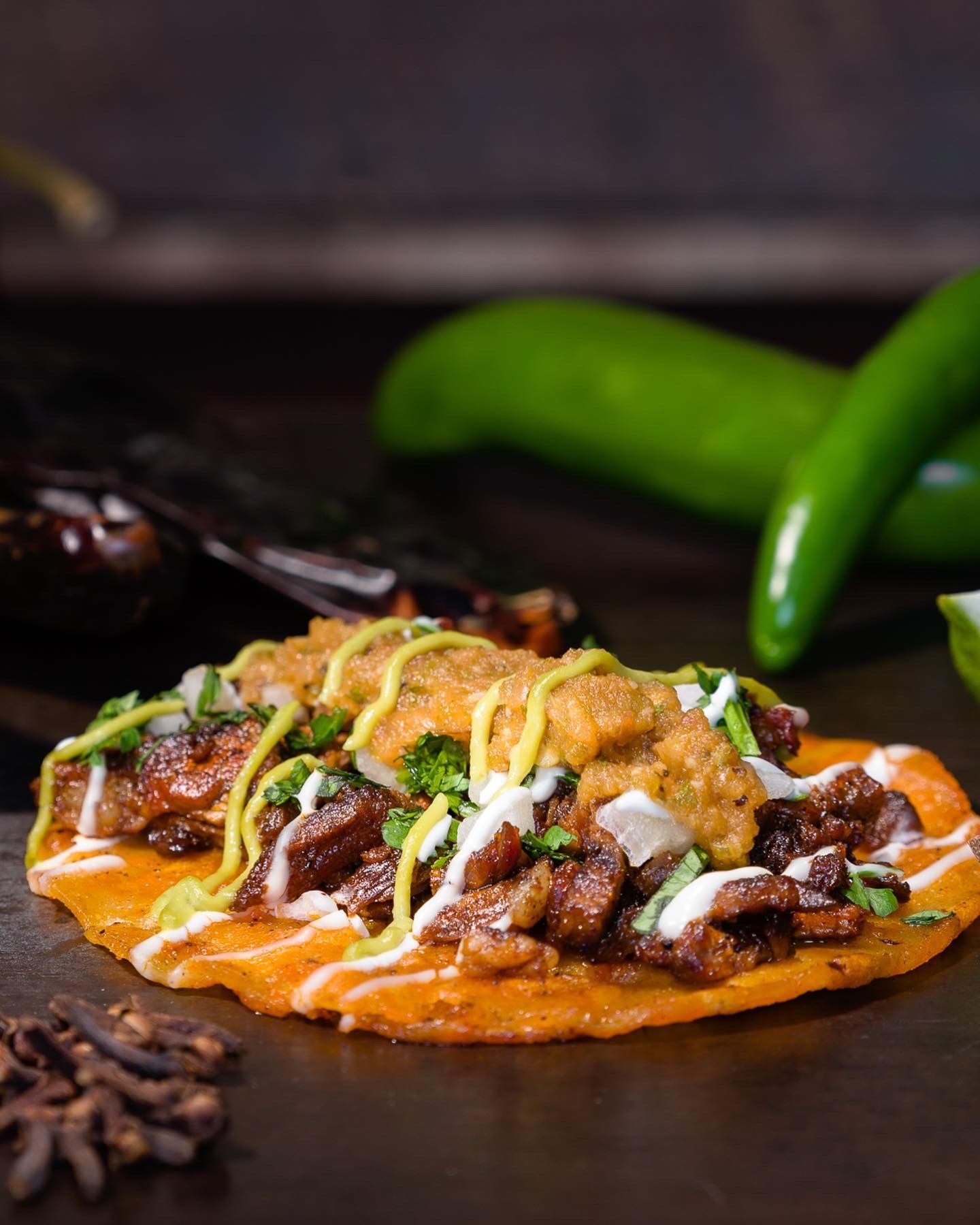Carne asada sonoran street taco with grilled meat, crema, pickled onions, and cotija cheese
