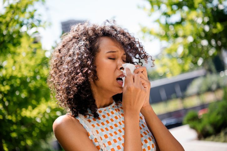 A woman is blowing her nose into a napkin.