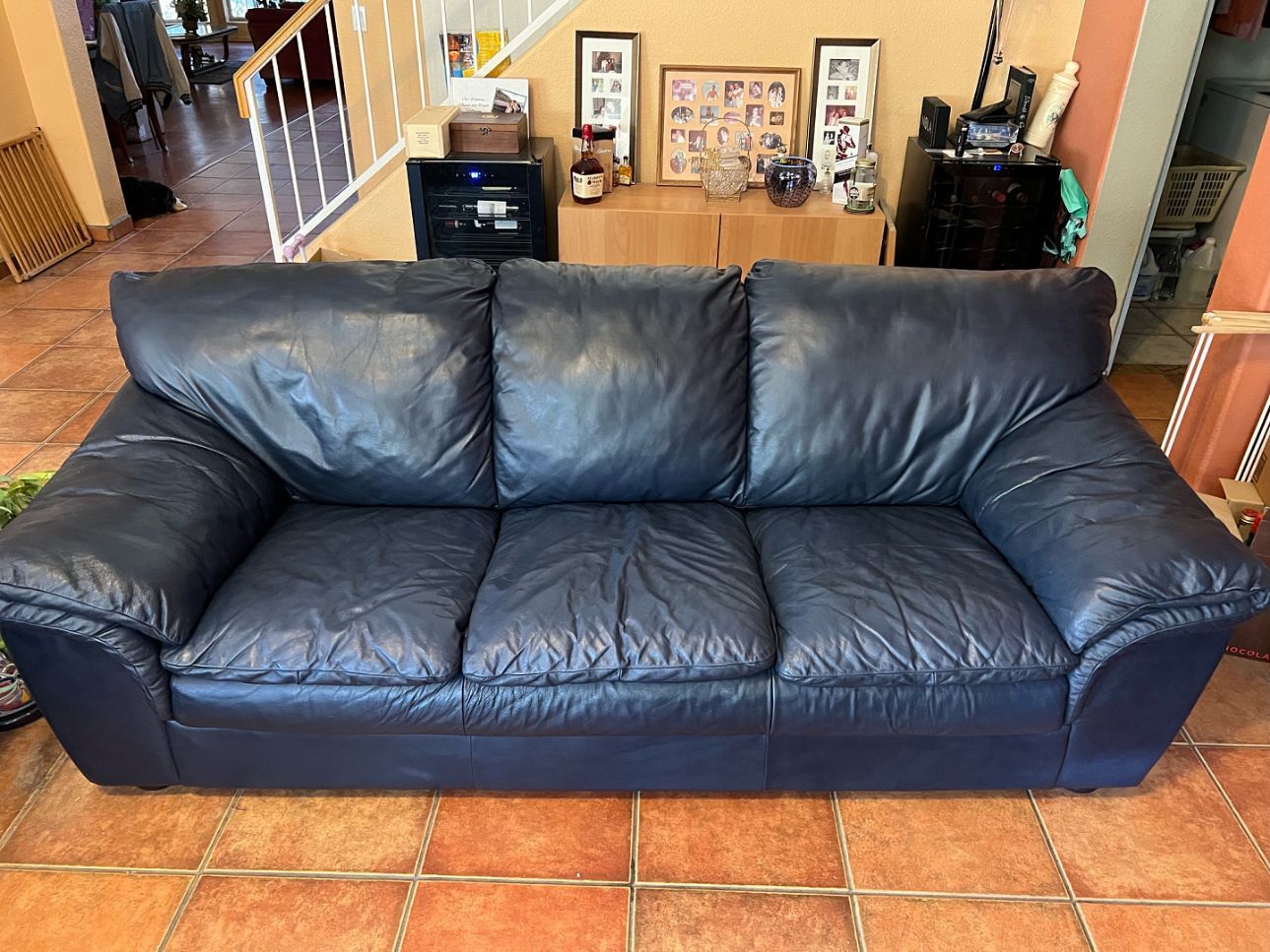 Blue leather three-seat sofa in a living room.