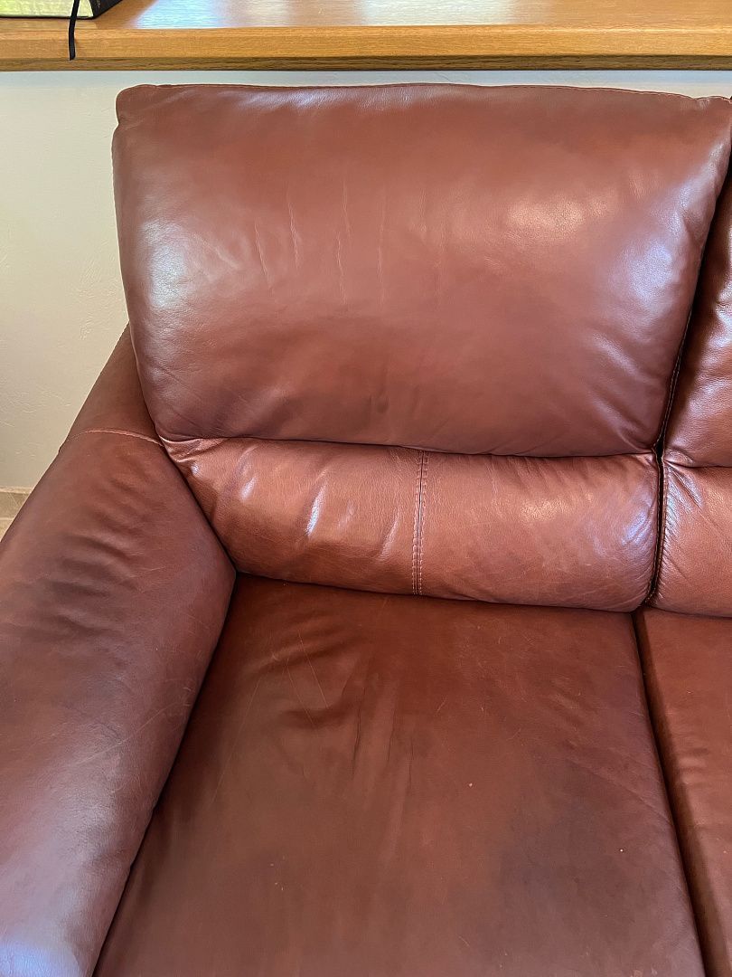 Red leather couch with headrest and arm visible.