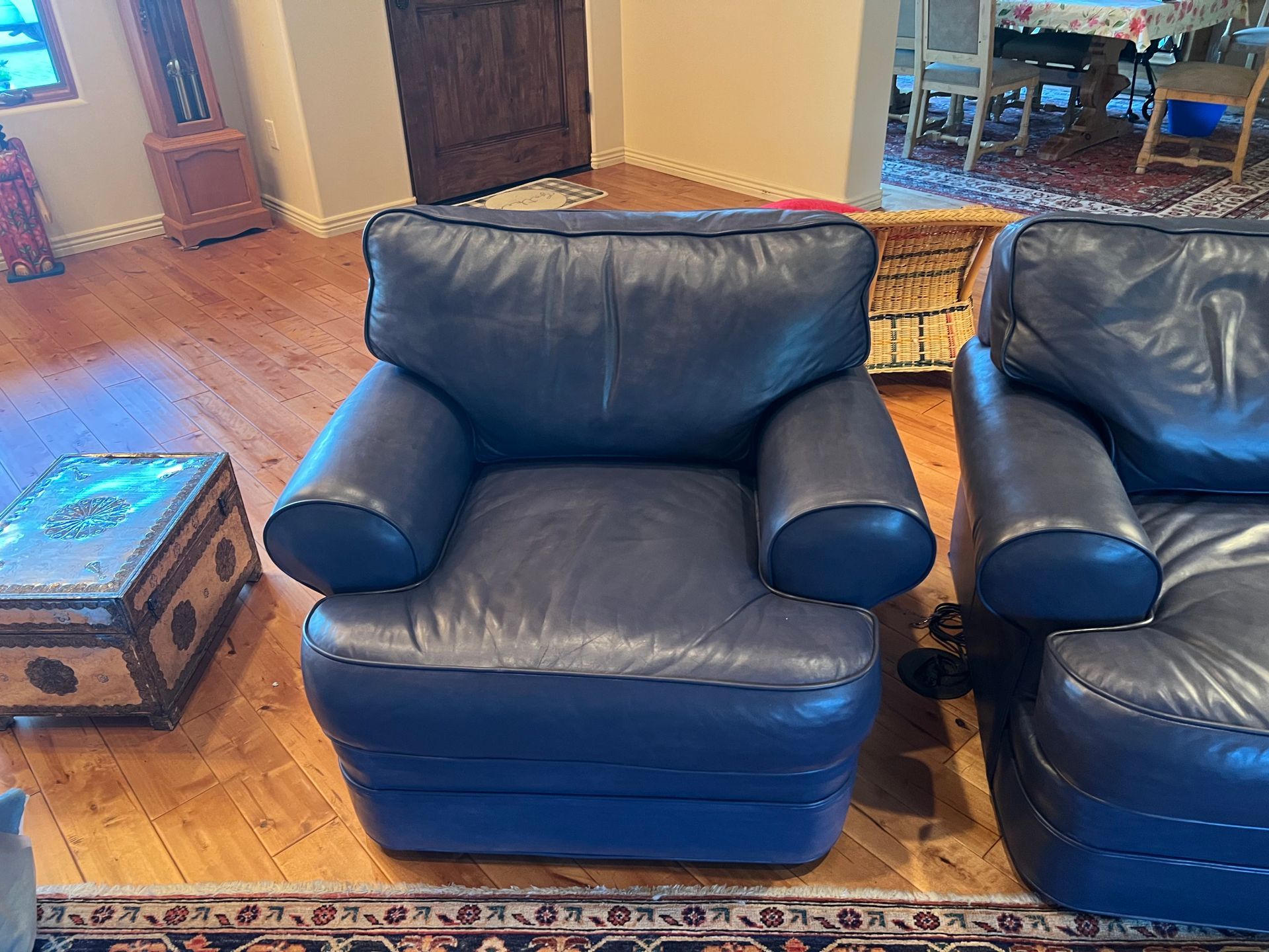 Two navy blue leather armchairs on wooden floor.