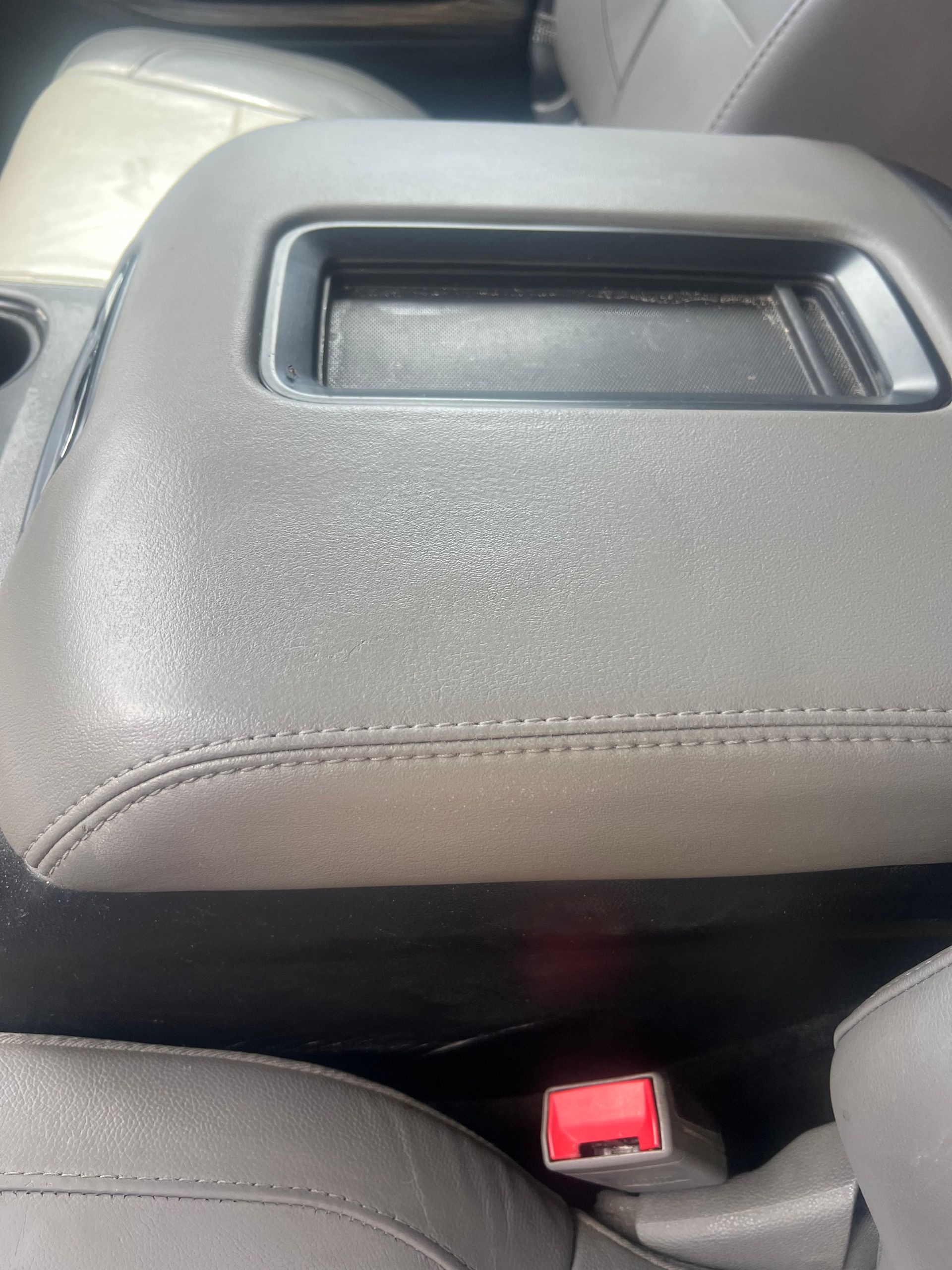 Gray car center console with a black storage area.