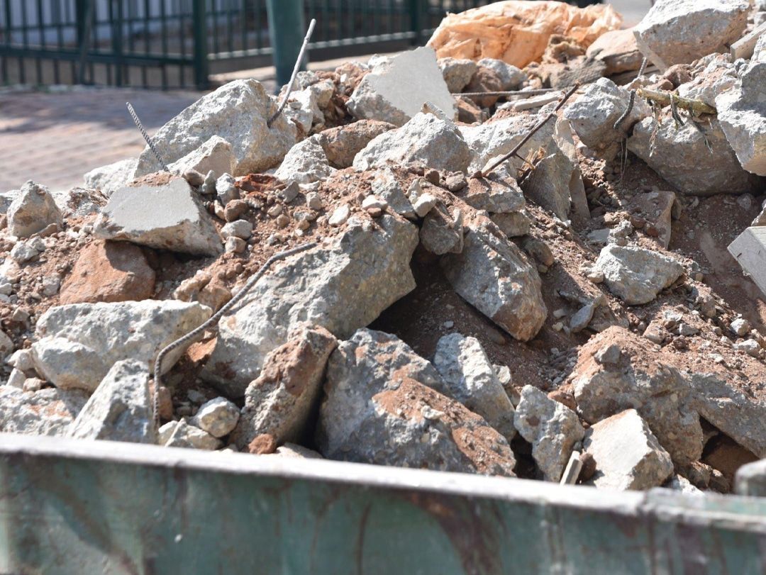 A pile of rocks and dirt in a dumpster.