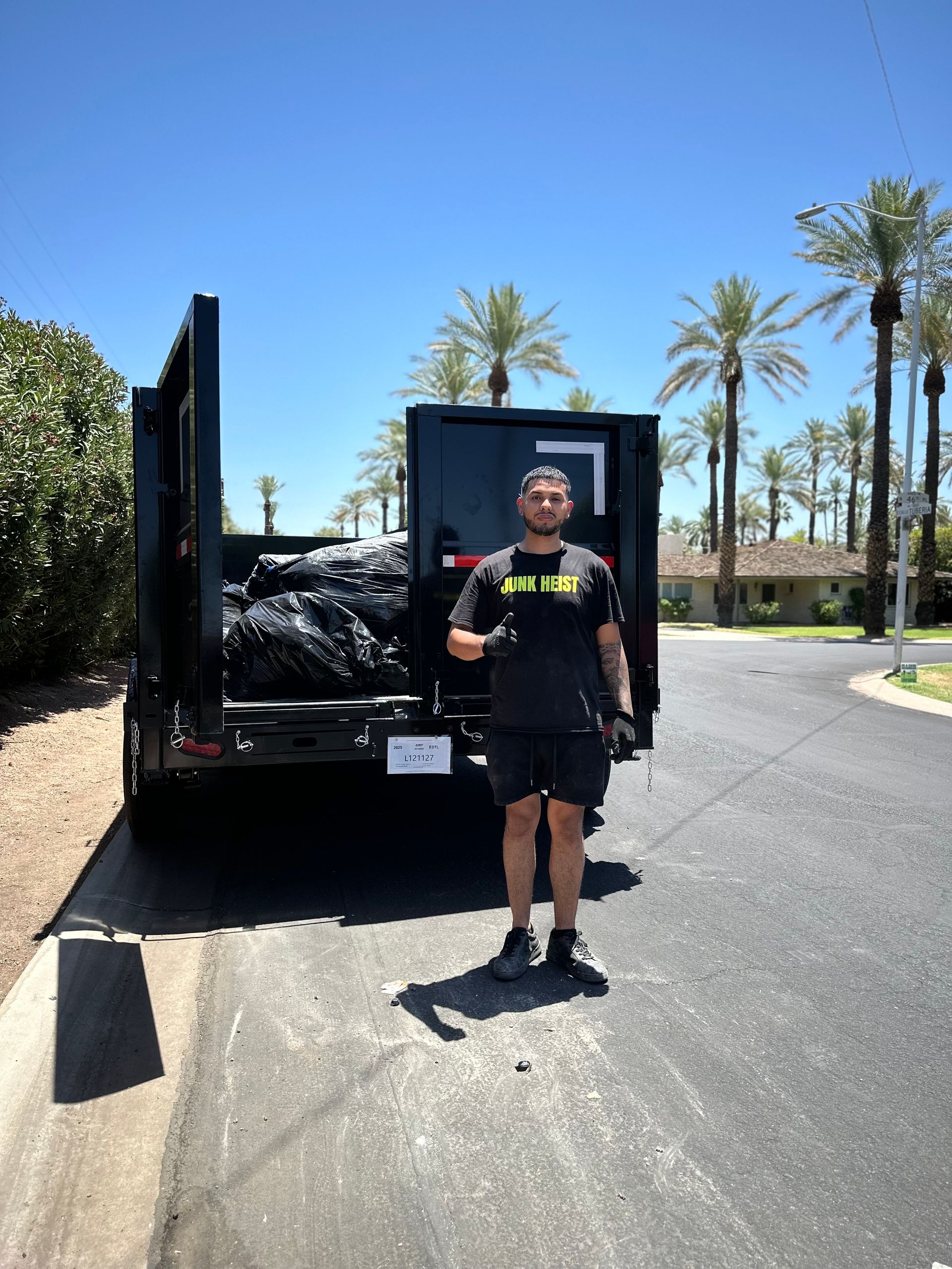 A man is standing next to a white truck in a driveway.