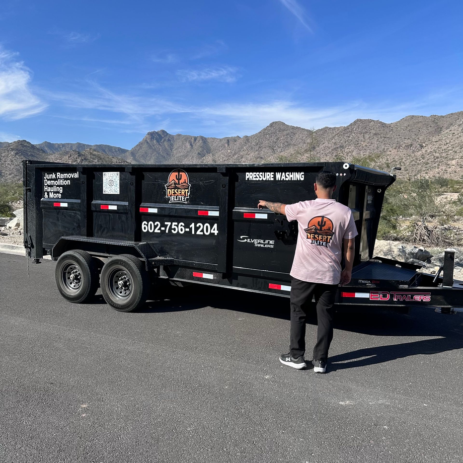 A man is standing next to a white truck in a driveway.