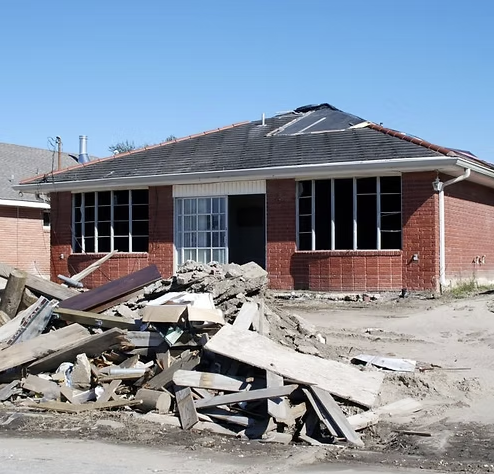 A brick house with a pile of wood in front of it
