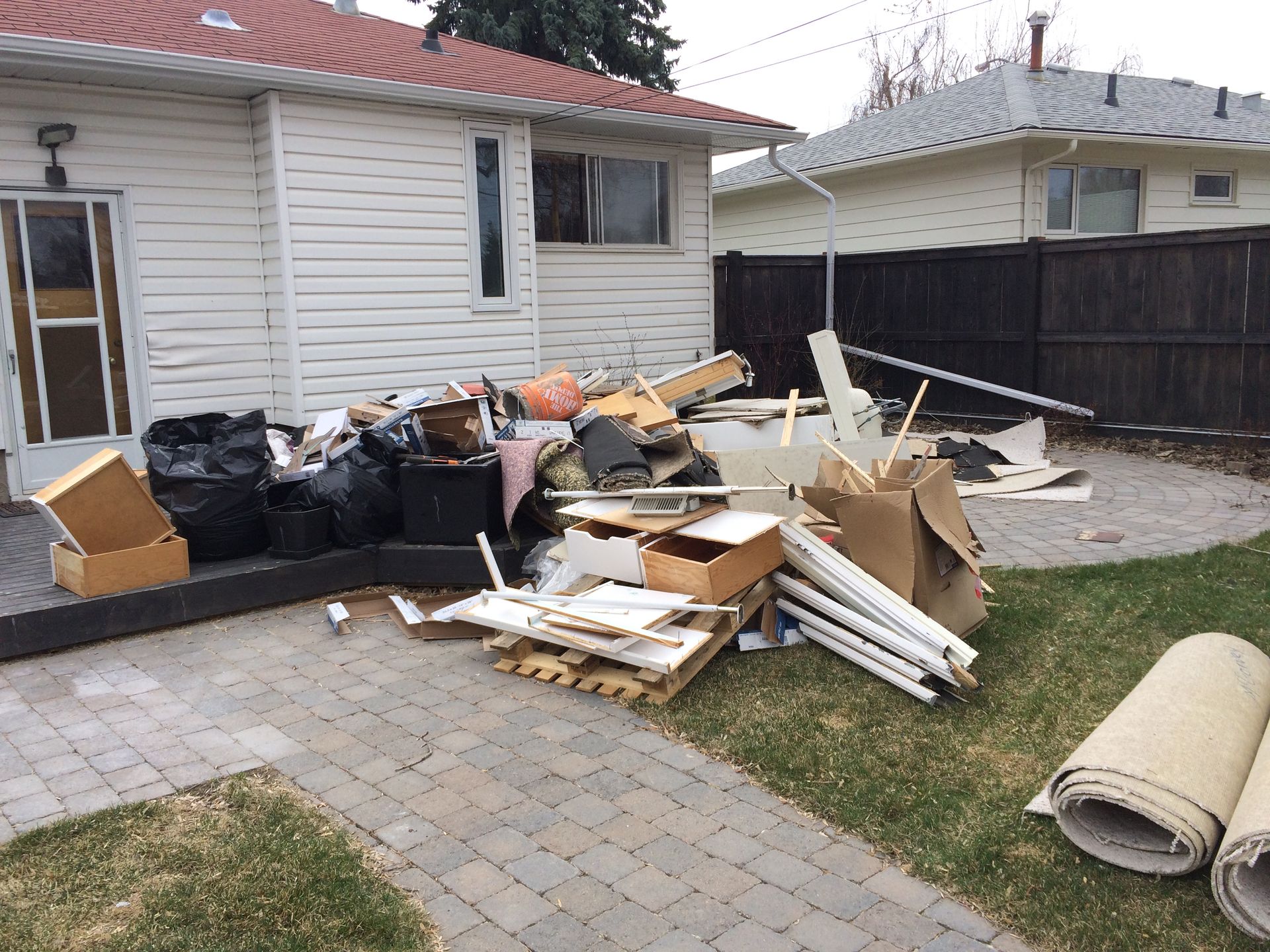 A pile of trash is sitting in front of a house.