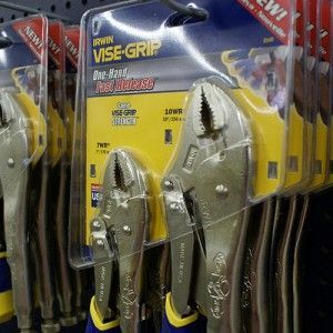 A pair of vise grip pliers sitting on top of a shelf.