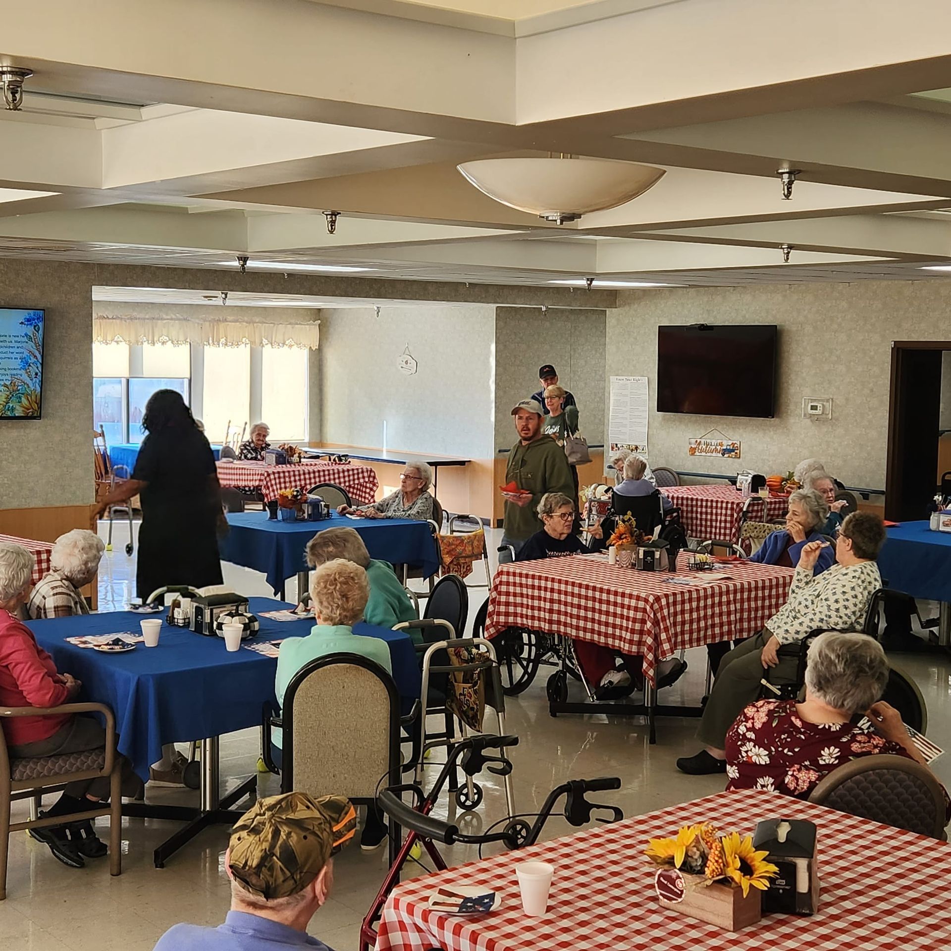 A group of people are sitting at tables in a large room.