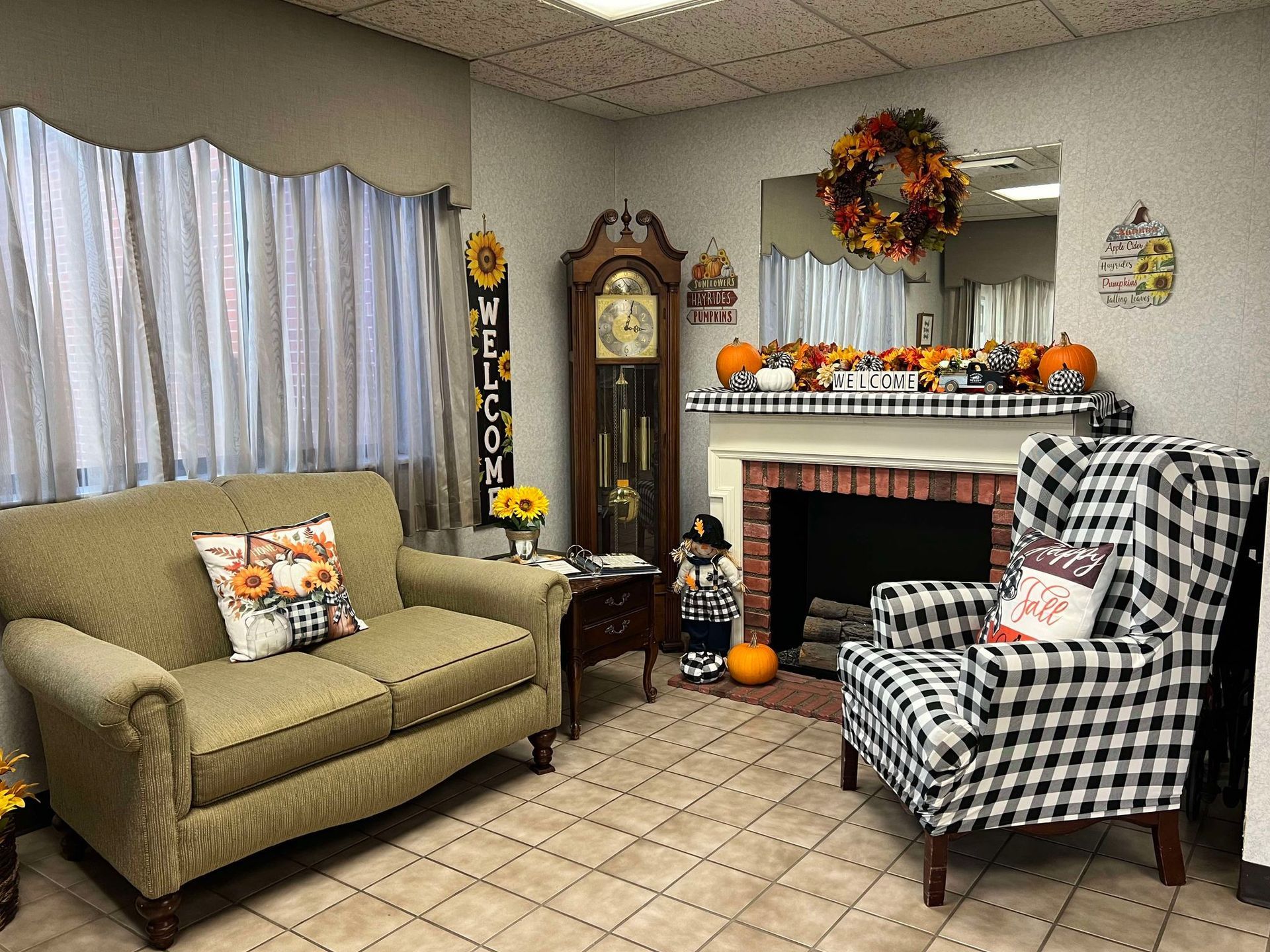 A living room with a couch , chair , fireplace and clock.