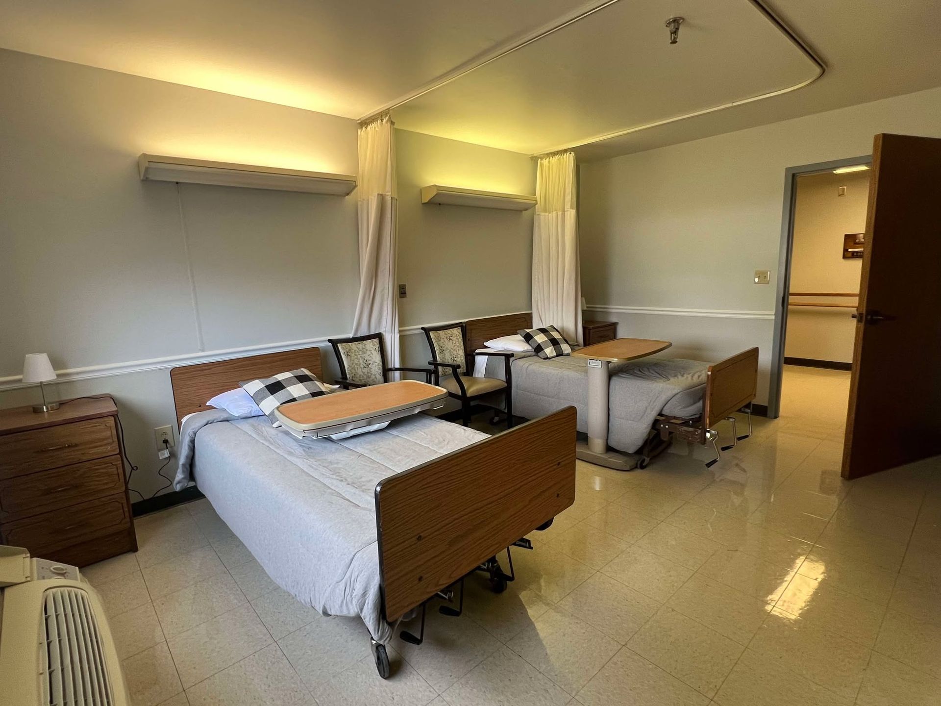A hospital room with two beds and a table.
