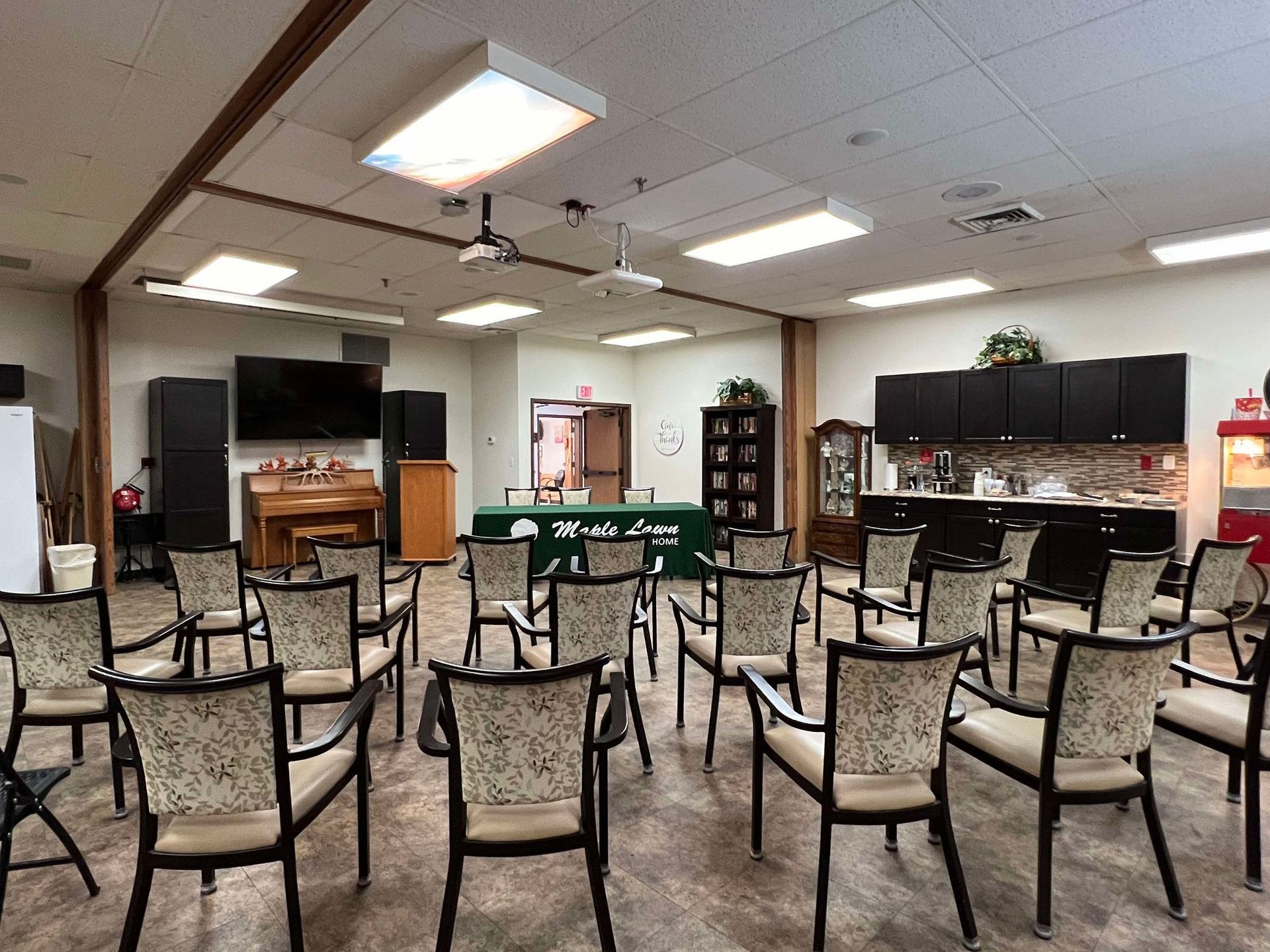 A large room filled with chairs and a popcorn machine.