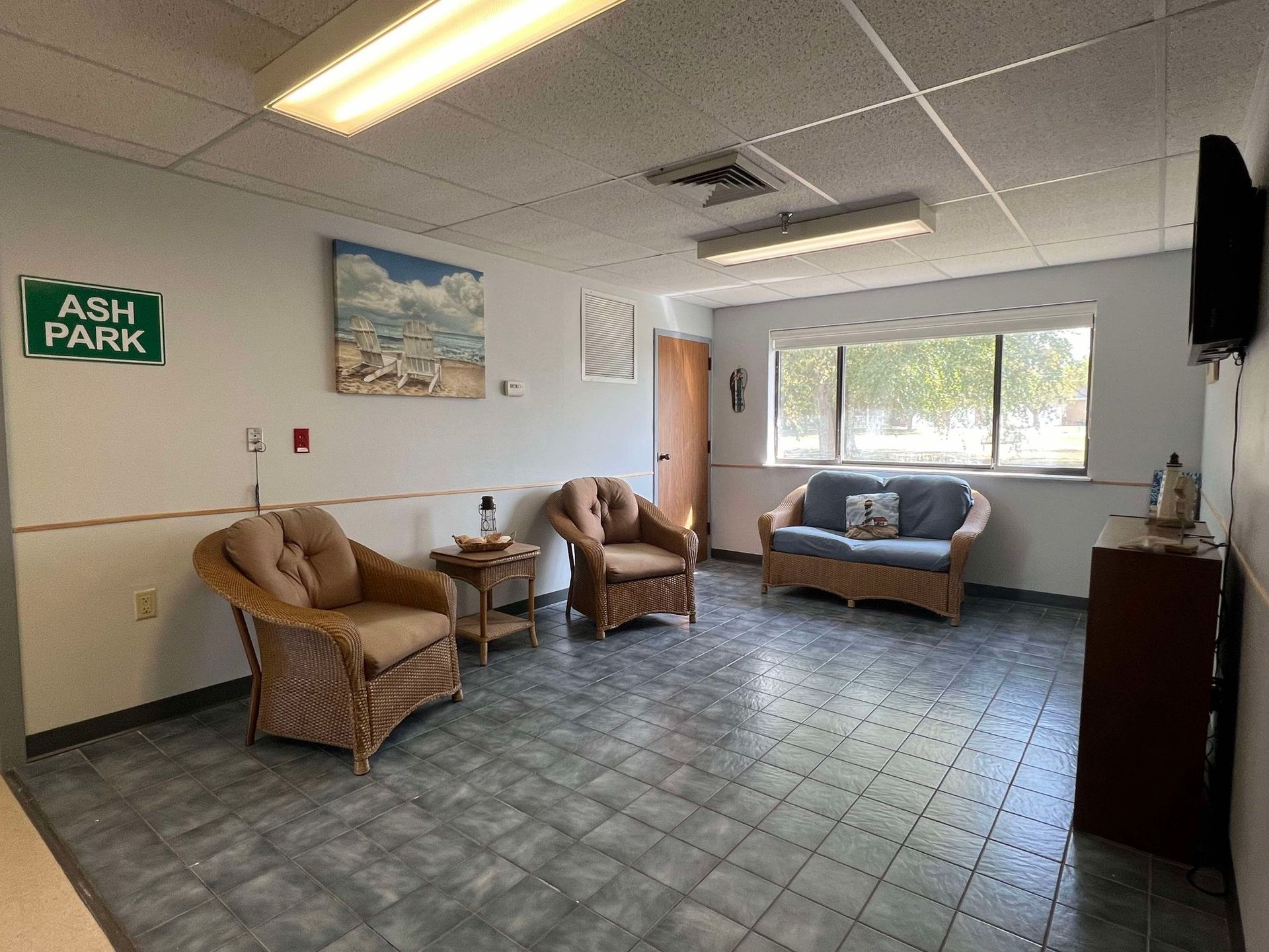 A living room with a couch , chairs and a sign that says ash park.