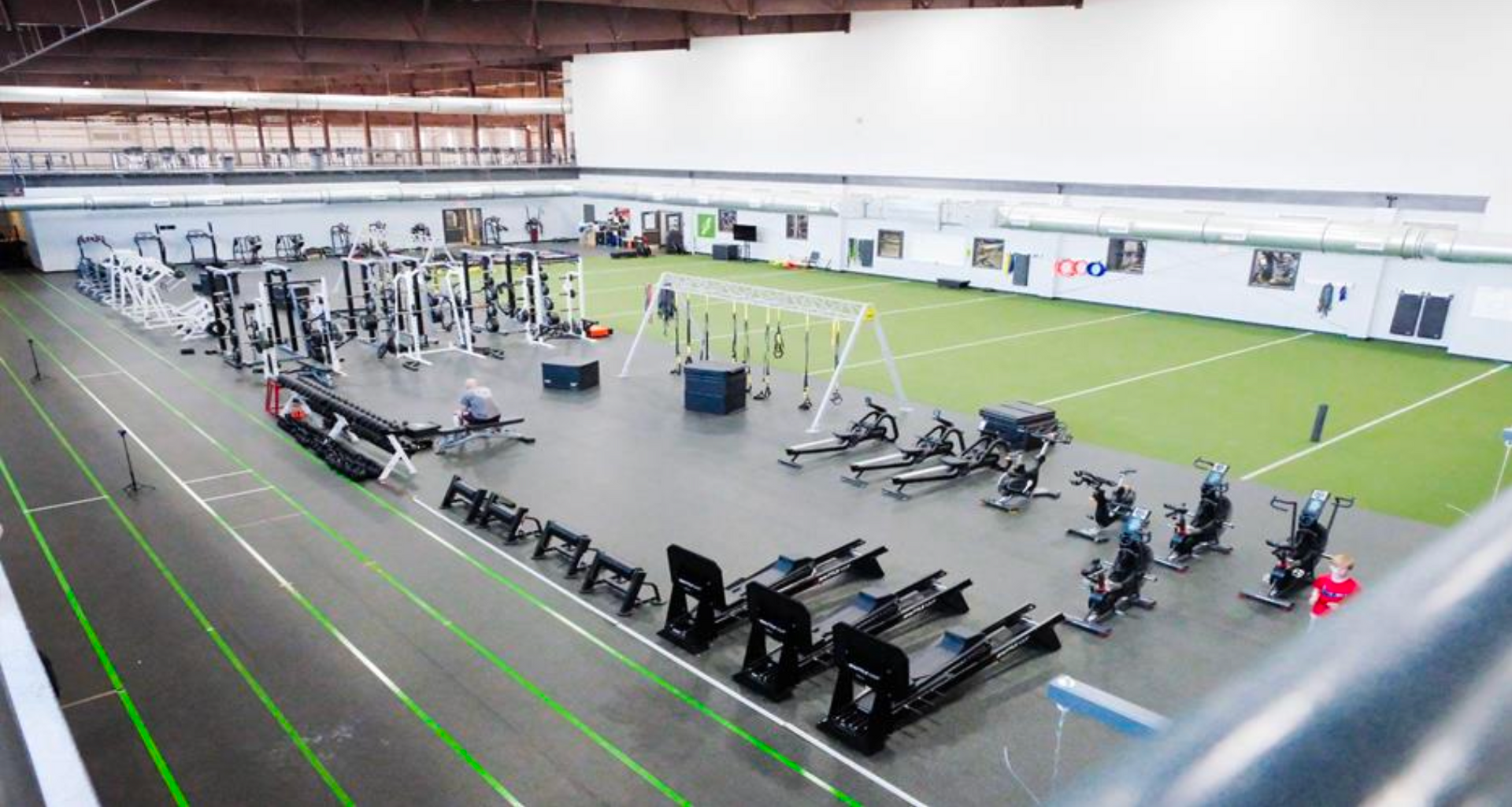 Large indoor gym with various exercise machines and a running track.