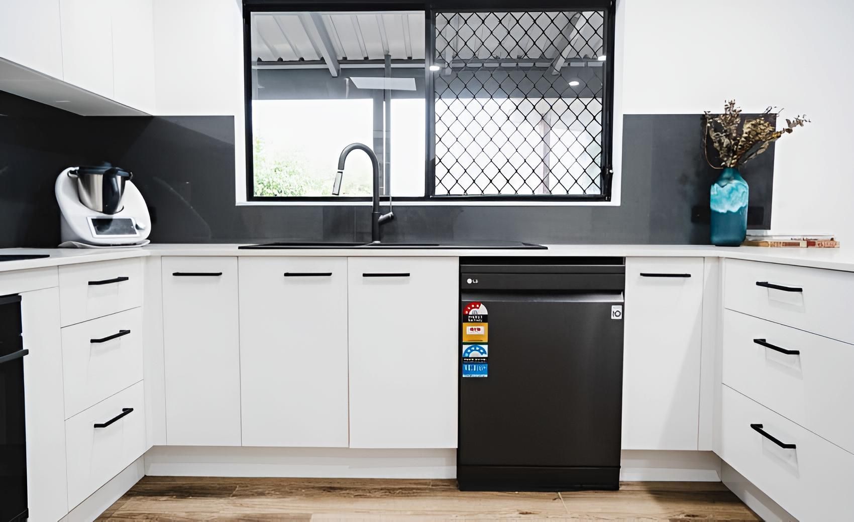 A Kitchen With White Cabinets and a Black Dishwasher — CK Cabinetry in Coolum Beach, QLD