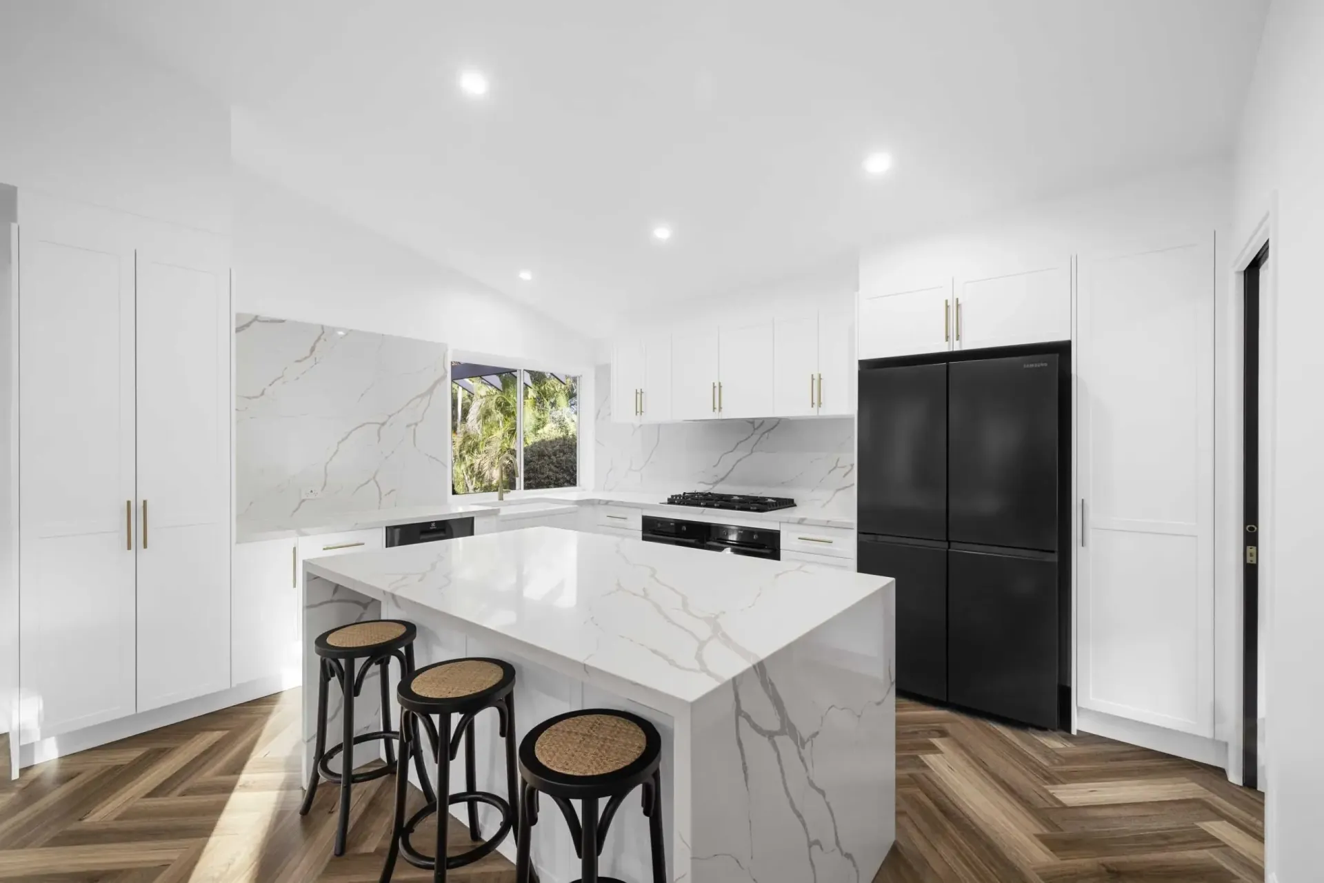 A kitchen with white cabinets, a large island — CK Cabinetry in Coolum Beach, QLD
