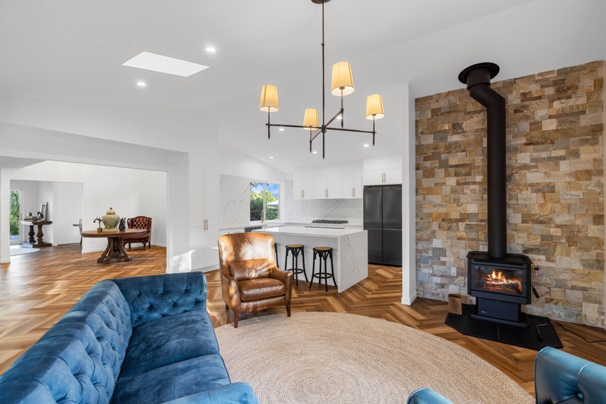 A Living Room With a Blue Couch and a Wood Stove — CK Cabinetry in Coolum Beach, QLD