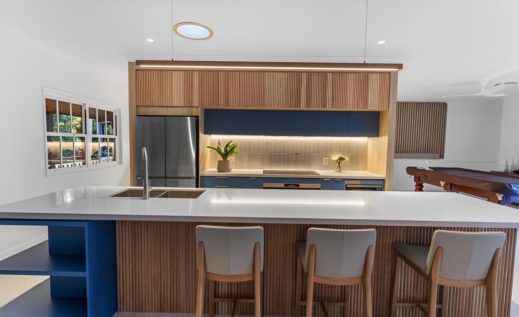 A Kitchen With a Large Island and Stools and a Pool Table — CK Cabinetry in Coolum Beach, QLD