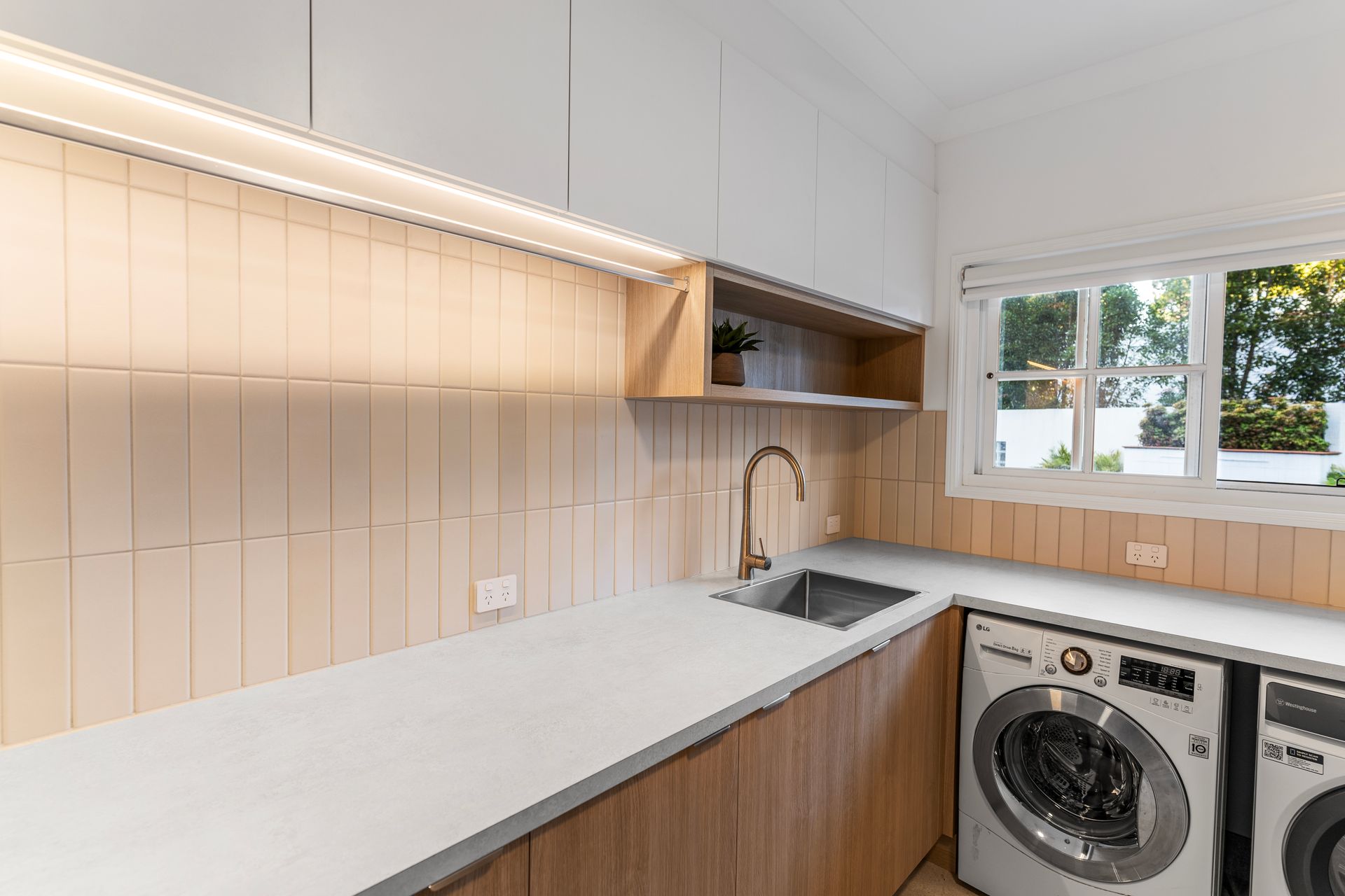 A Laundry Room With a Washer and Dryer Stacked on Top of Each Other — CK Cabinetry in Coolum Beach, QLD
